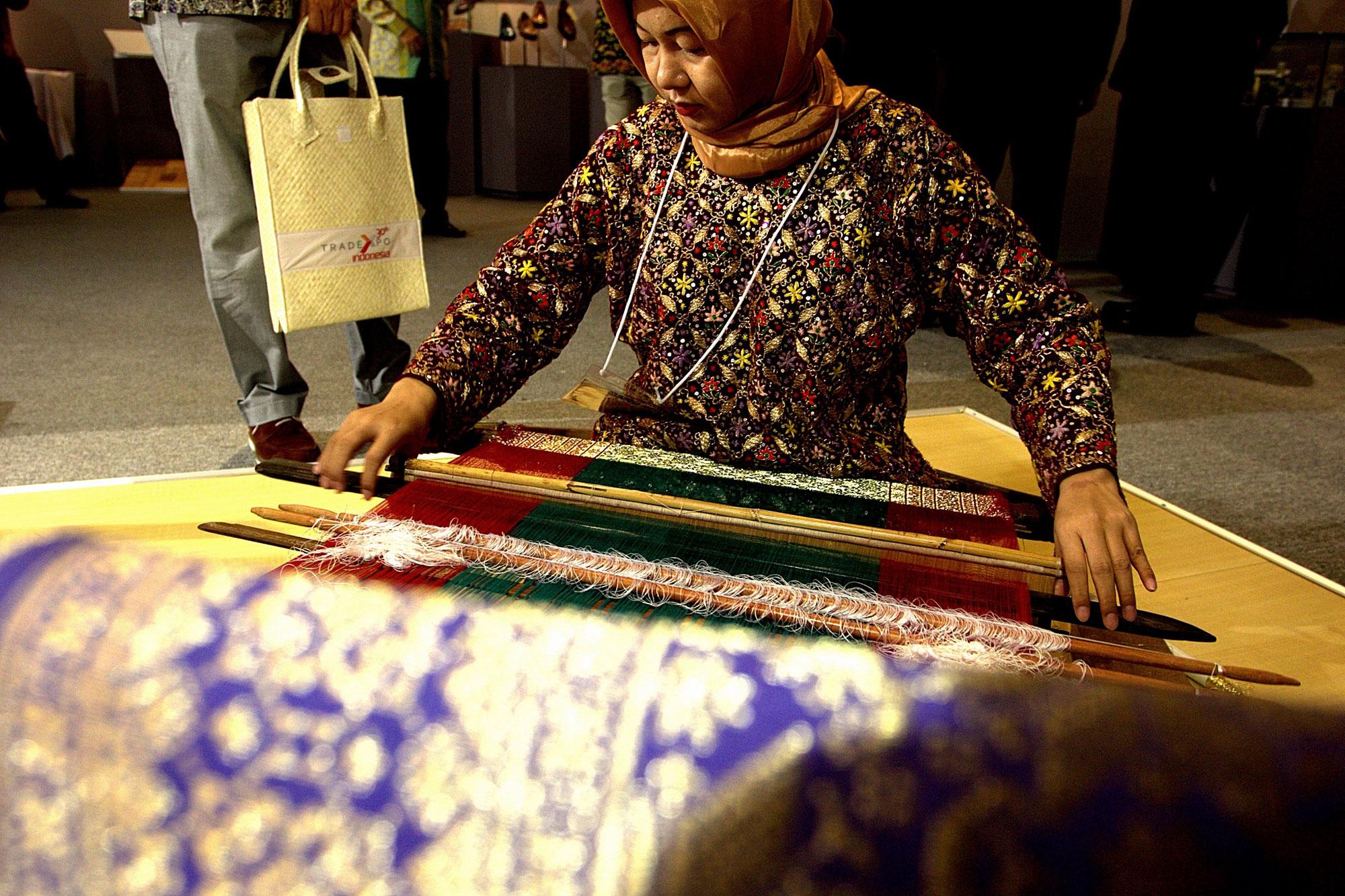 Pengunjung memperhatikan produk kain tenun di salah satu gerai peserta pameran Trade Expo Indonesia ke-30 Tahun 2015 di Arena Pekan Raya Jakarta, Kemayoran, Jakarta, Rabu (21/10). Pameran tahunan yang menampilkan berbagai produk Indonesia berkualitas eksp