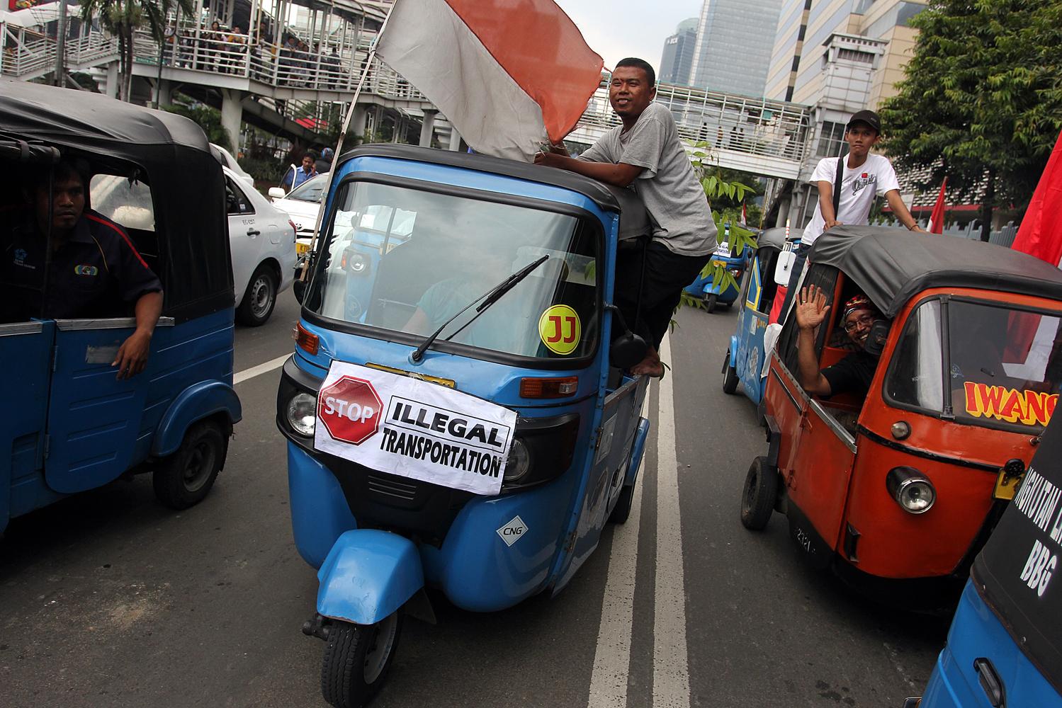 Aksi demonstrasi para sopir taksi juga diikuti oleh pengemudi bajaj yang menolak layanan angkutan berbasiskan aplikasi online di sepanjang Jalan Sudirman-Thamrin, Jakarta, Selasa, (22/3).