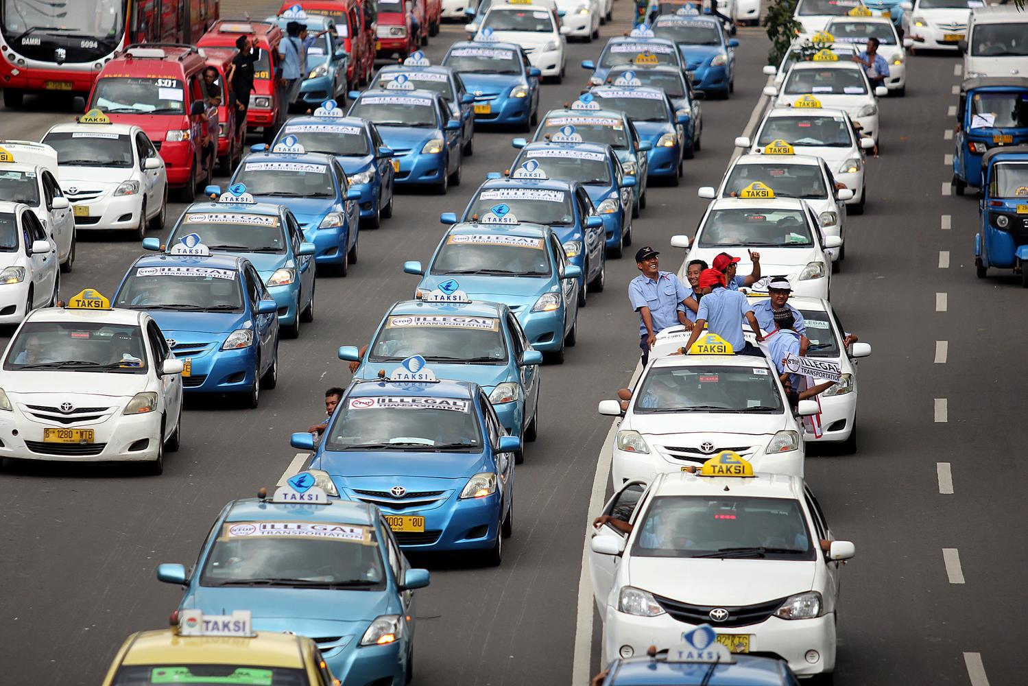 Konvoi para pengemudi taksi dan angkutan umum menuntut penutupan layanan angkutan berbasiskan aplikasi online.