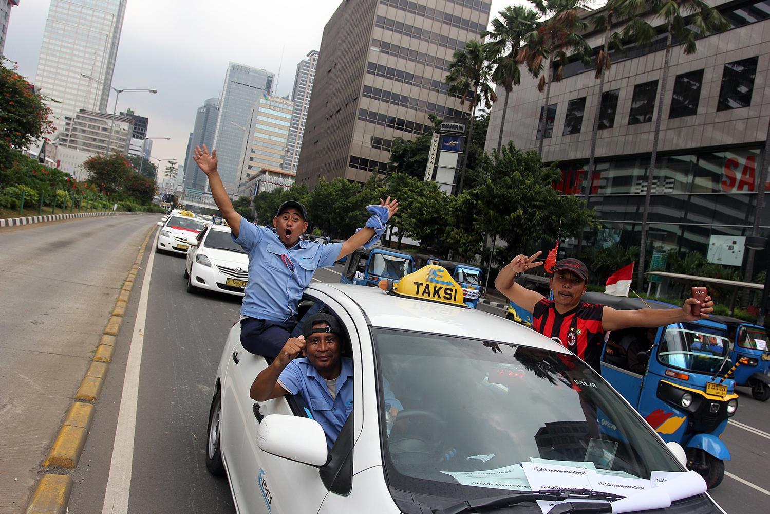 Aksi demonstrasi para sopir taksi dan angkutan umum menolak layanan angkutan berbasiskan online di sepanjang Jalan Sudirman-Thamrin, Jakarta, Selasa, (22/3).