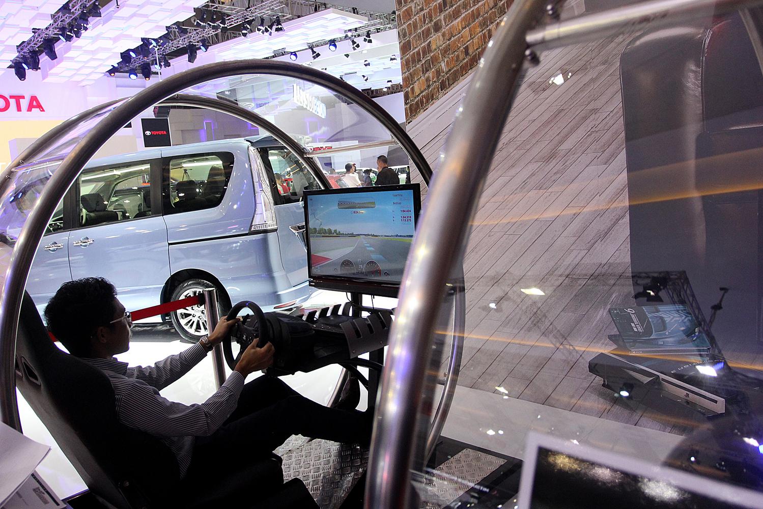 Pengunjung mencoba simulator mobil di arena pameran otomotif Indonesia International Motor Show (IIMS) 2016.