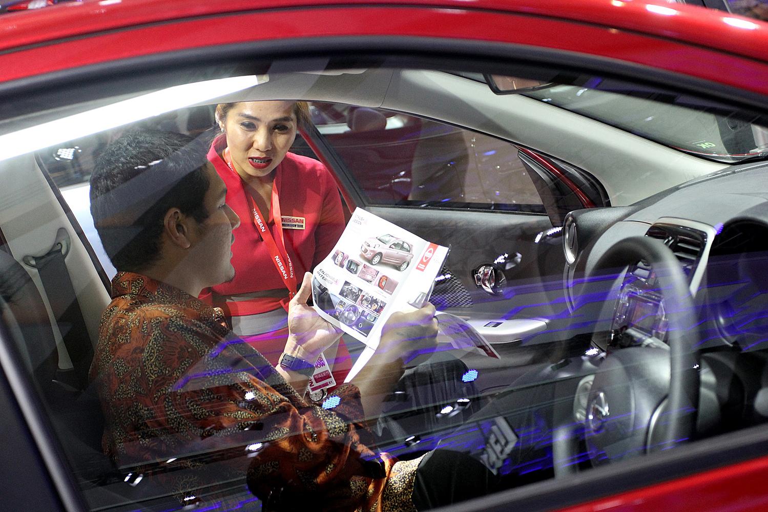 Pengunjung mencoba produk mobil pada arena pameran otomotif Indonesia International Motor Show (IIMS) 2016 saat pembukaan di Jakarta, Kamis (7/4). Pemeran otomotif yang akan berlangsung hingga 17 April 2016 itu diikuti pelaku industri otomotif di tanah air dengan menampilkan produk unggulan.