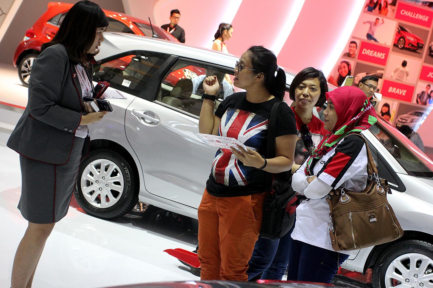 Pengunjung bertanya mengenai salah satu produk mobil pada arena pameran otomotif Indonesia International Motor Show (IIMS) 2016 saat pembukaan di Jakarta, Kamis (7/4). Pemeran otomotif yang akan berlangsung hingga 17 April 2016 itu diikuti pelaku industri otomotif di tanah air dengan menampilkan produk unggulan.