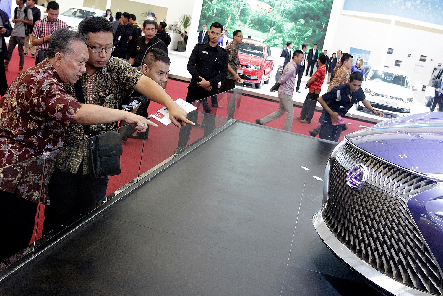 Pengunjung memperhatikan sebuah mobil yang dipamerkan di Gaikindo Indonesia International Auto Show (GIIAS) ke- 24.