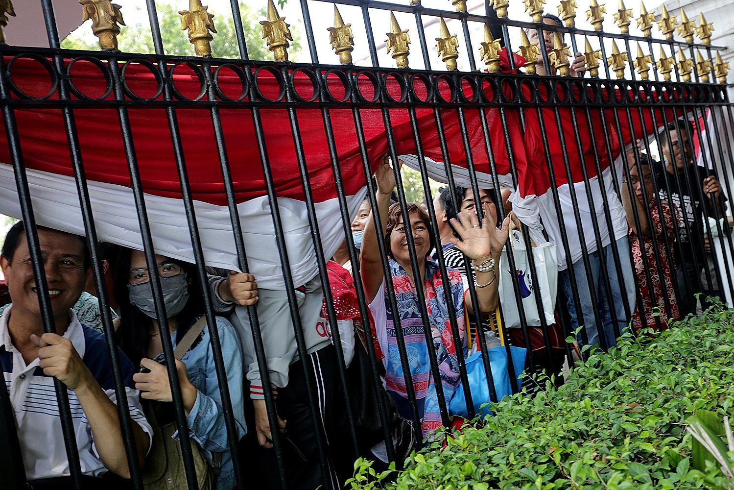 Masyarakat menyaksikan Upacara pengibaran bendera 17 Agustus 2016 dari balik pagar Istana Merdeka, Jakarta, Rabu, (17/08).