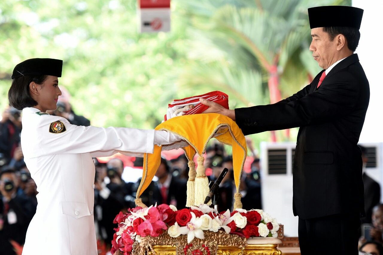 Presiden Joko Widodo (kanan) menyerahkan Sang Saka Merah Putih kepada petugas pembawa baki Pasukan Pengibar Bendera Pusaka (Paskibraka) Nilam Sukma Pawening saat upacara Peringatan Hari Kemerdekaan ke-71 RI di Istana Merdeka, Jakarta, Rabu (17/8).