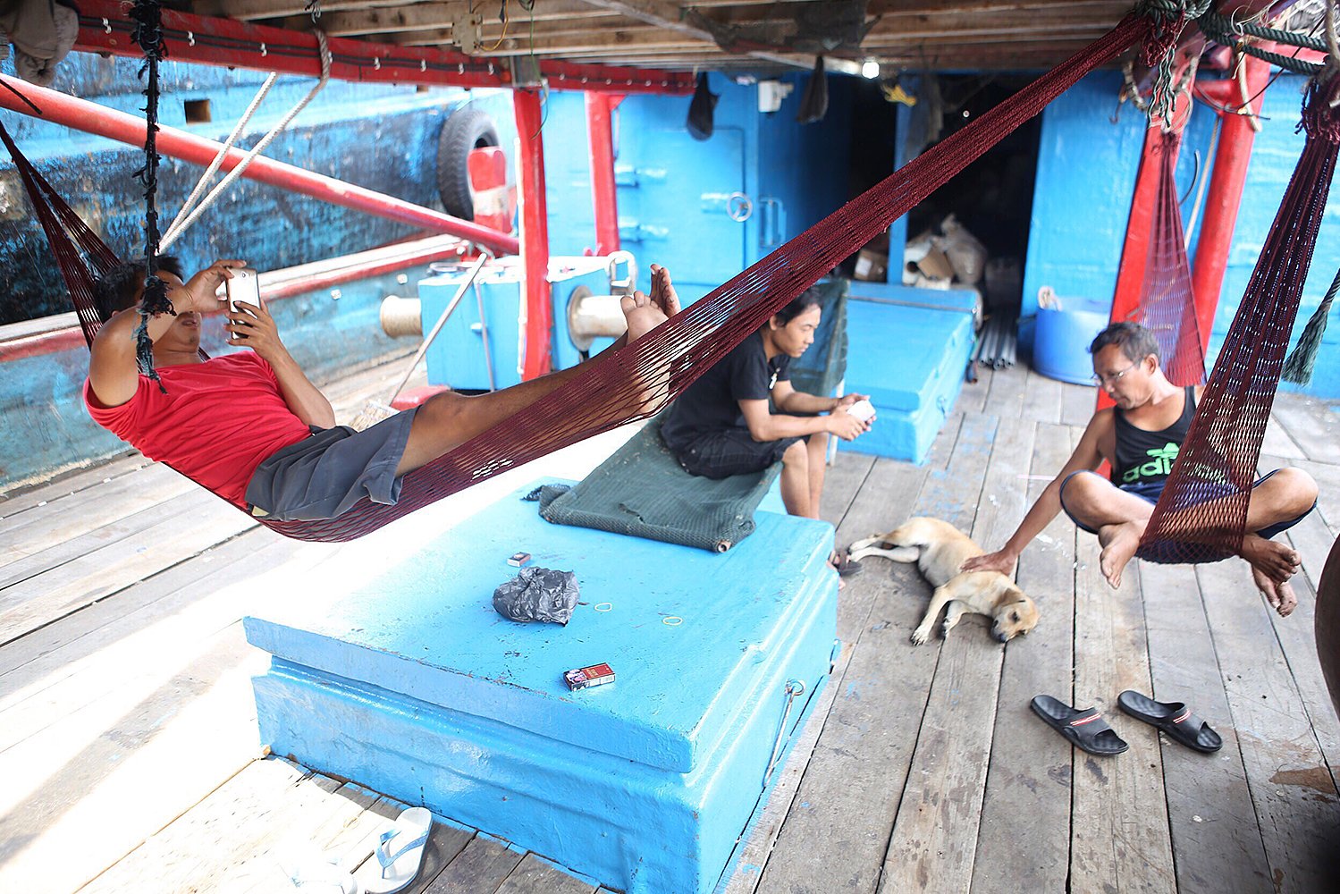 Nelayan mengisi waktu dengan bersantai di geladak kapal yang bersandar di Pelabuhan Muara Baru, Jakarta.