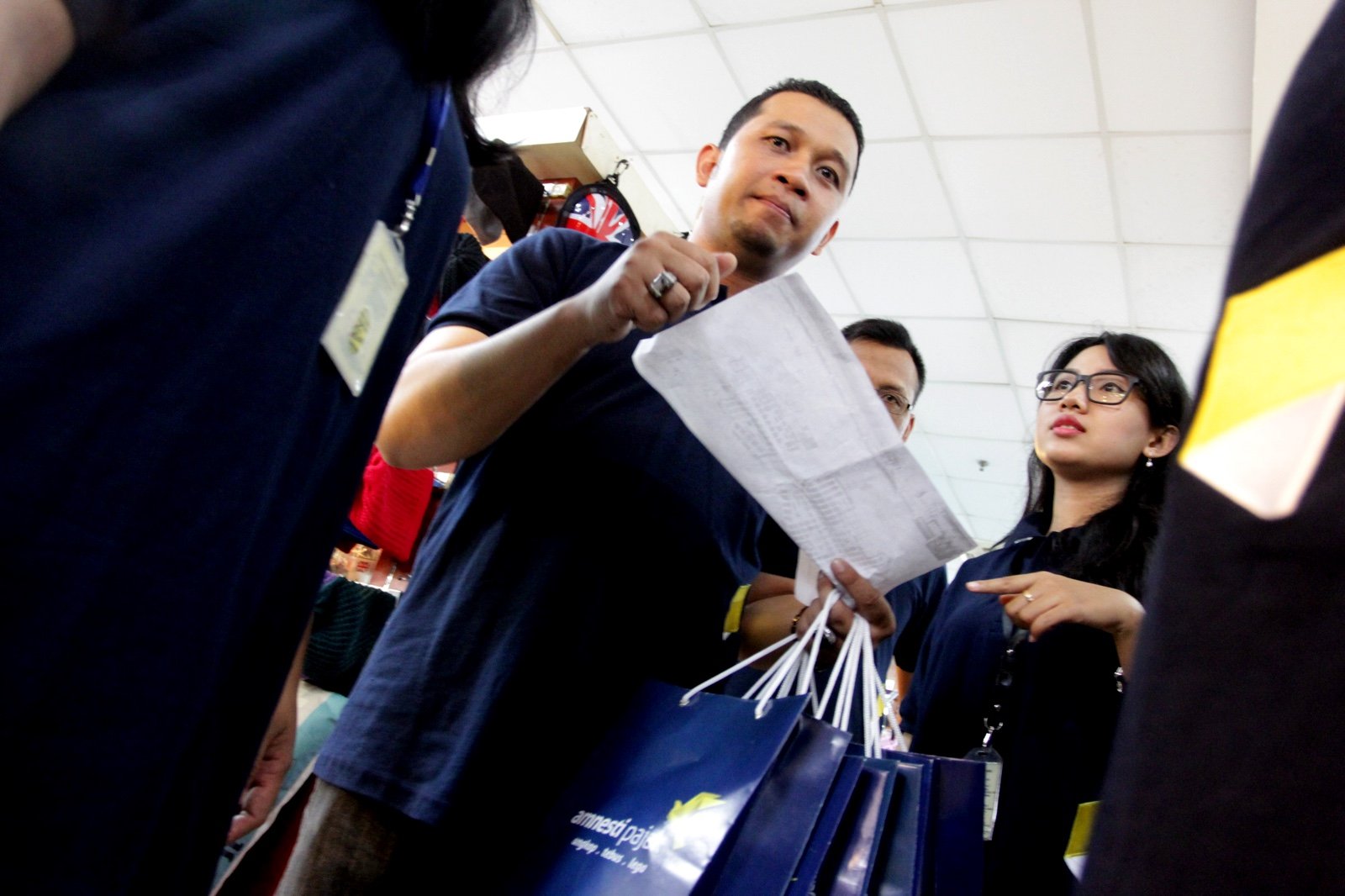 Petugas pajak saat sosialisasi tax amnesty untuk UMKM di pusat perbelanjaan dan grosir tekstil, Thamrin City, Jakarta, Kamis (1/12).