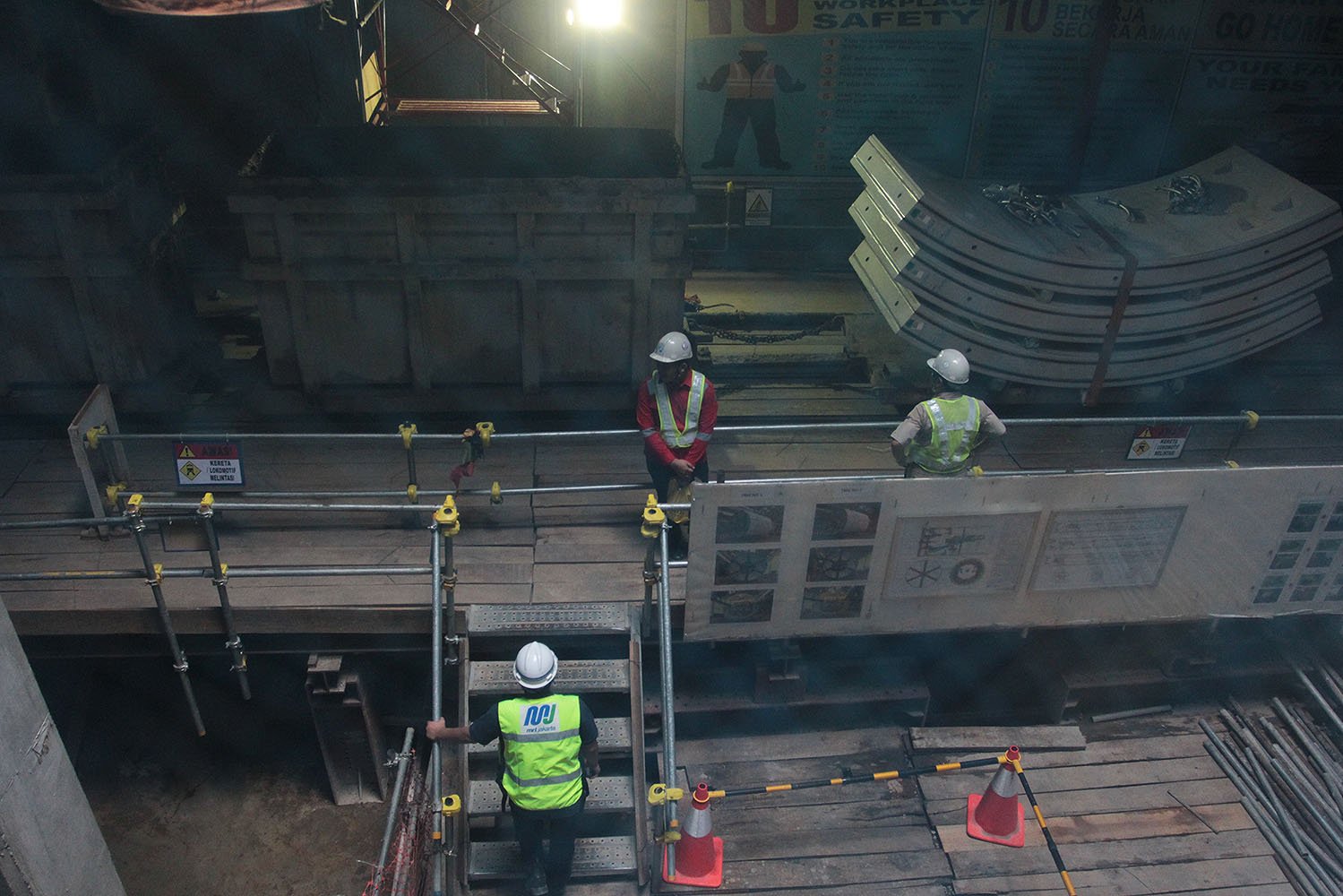 Para pekerja menurunkan panel sekmen penutup badan terowongan bawah tanah, yang merupakan bagian dari proyek pembangunan kereta massal atau Mass Rapid Transit (MRT) di kawasan Bundaran Hotel Indonesia, Jakarta, Rabu (14/12).