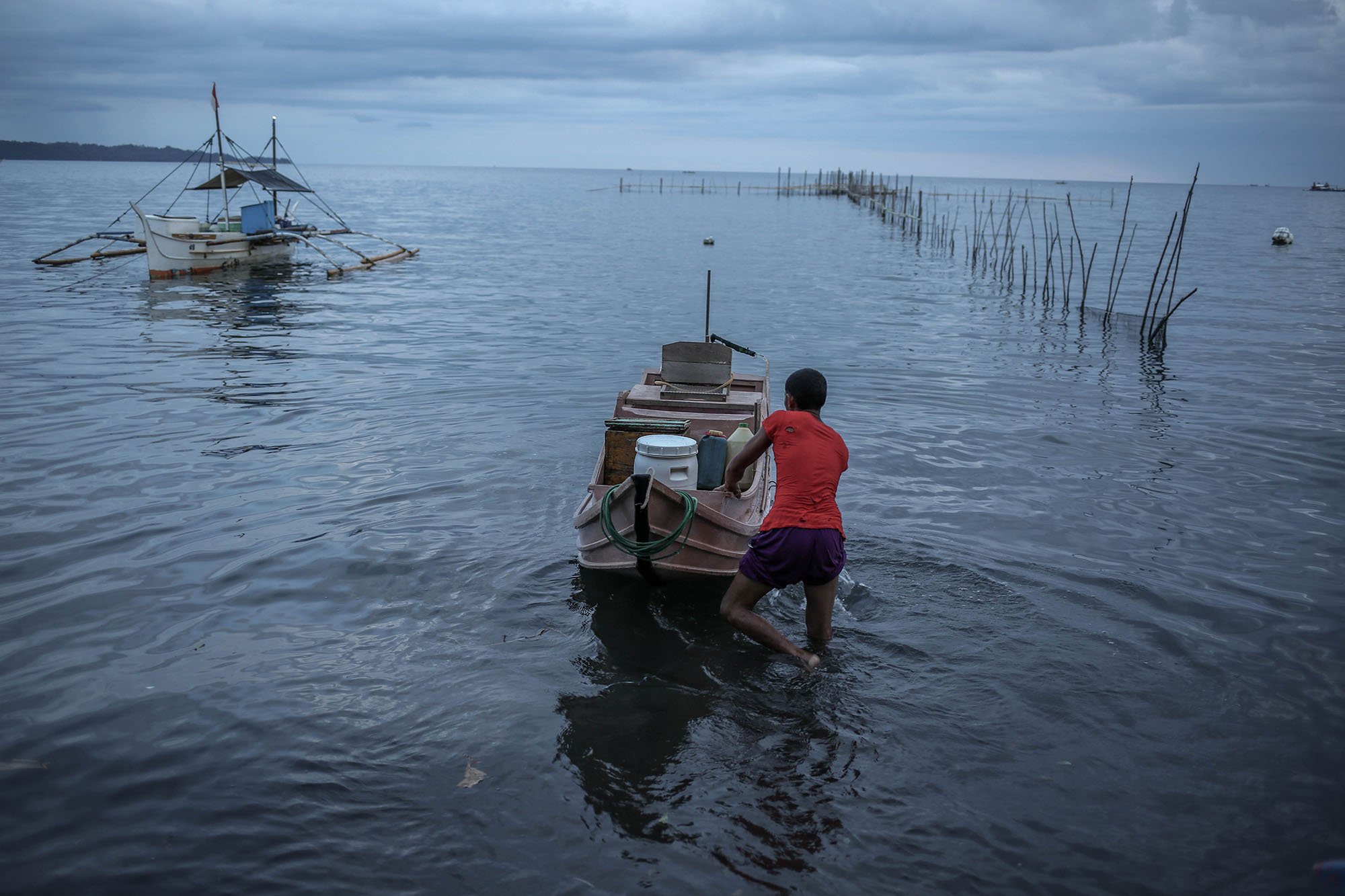 Seorang nelayan mendorong perahu Pakura miliknya untuk pergi melaut. Pakura banyak digunakan oleh nelayan-nelayan Filipina untuk menangkap tuna.