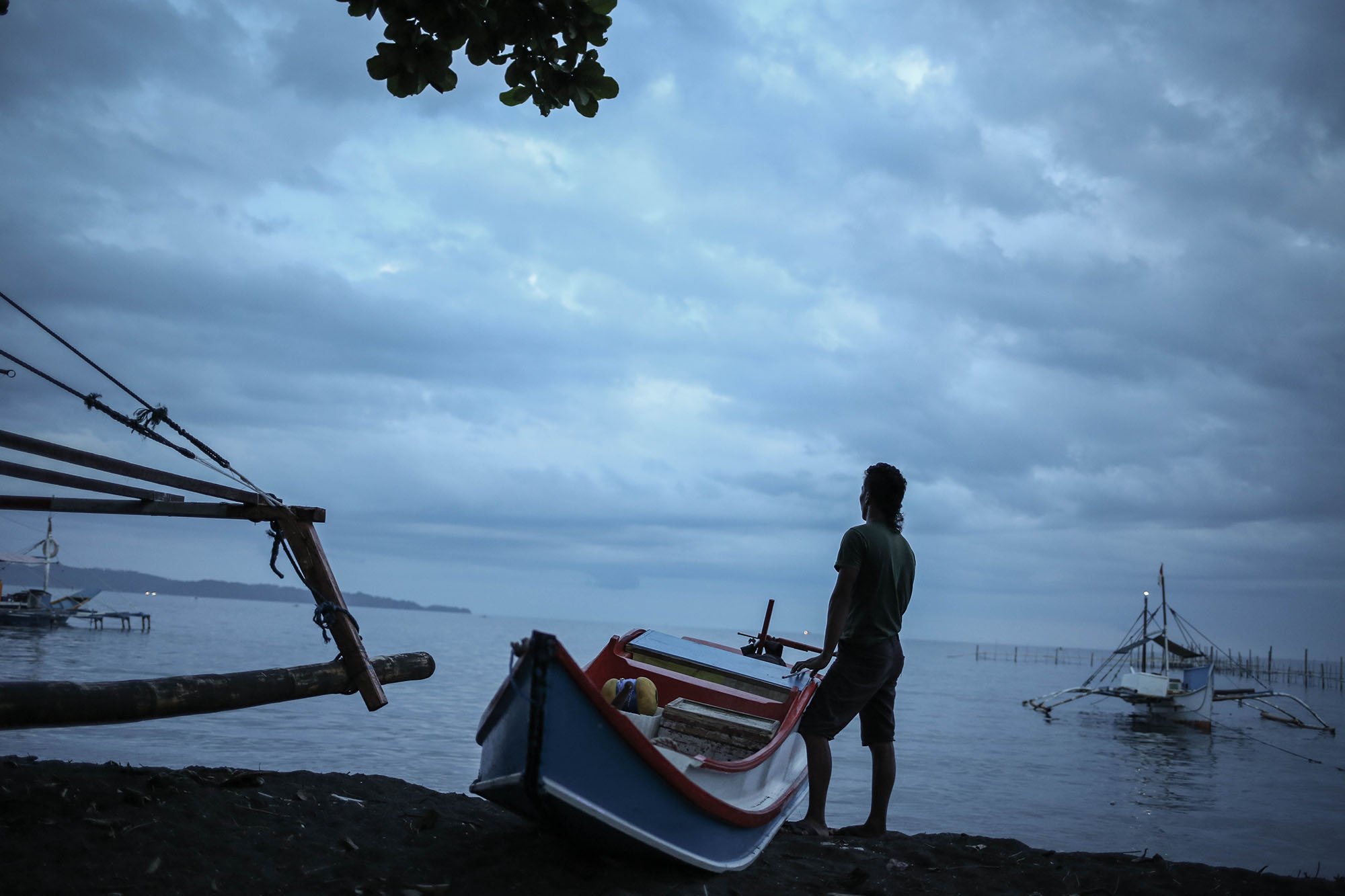 Seorang nelayan berdiri dekat perahu Pakura miliknya saat hendak pergi melaut. Pakura banyak digunakan oleh nelayan-nelayan Filipina untuk menangkap tuna.