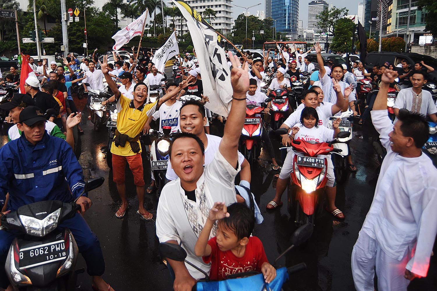 Para pendukung pasangan Anies-Sandi berkonvoi melintasi kawasan Bundaran HI, Jakarta, Rabu (19/4), setelah hasil hitung cepat semua lembaga survei memenangkan pasangan jagoannya. 