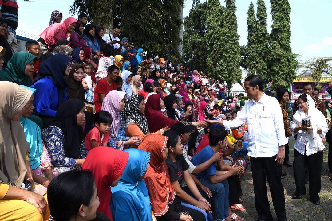 Presiden Joko Widodo dan Ibu Negara Iriana (kanan), membagikan sembako kepada warga, Rabu (21/6)