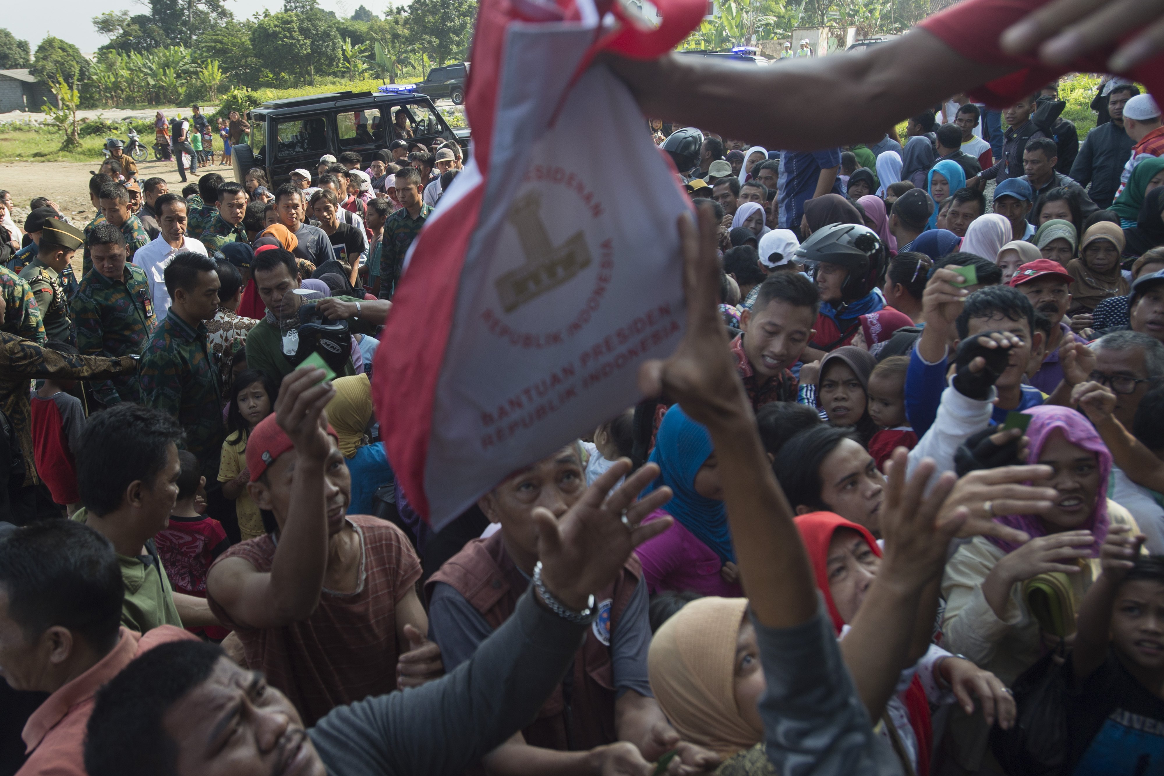Presiden Joko Widodo (kiri) memantau pembagian sembako kepada warga di Kampung Ciawi, Kota Bogor, Jawa Barat, Rabu (21/6). Sebanyak 3.000 paket sembako dibagikan dalam kegiatan tersebut. 