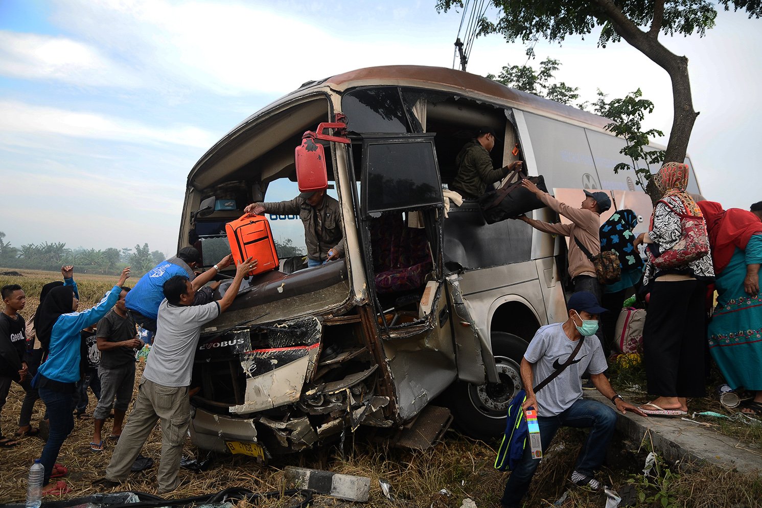 Para penumpang menurunkan barang bawaannya dari dalam bus yang mengalami kecelakaan di Jalur Pantura Desa Klaling, Kudus, Jawa Tengah, Rabu (21/6).