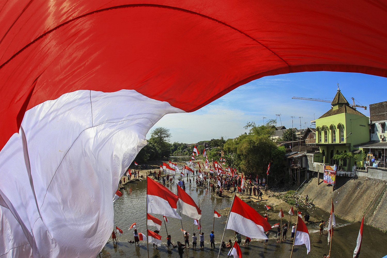 Warga mengikuti upacara bendera di Sungai Kalianyar, Banjarsari, Solo, Jawa Tengah, Kamis (17/8). Kegiatan upacara di sungai tersebut digelar untuk peringatan HUT Ke-72 RI sekaligus sebagai kampanye pelestarian sungai. 