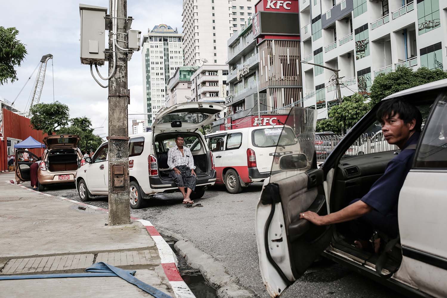 Supir taksi menanti penumpang di pinggir jalan kota Yangon, Myanmar. Berkurangnya kunjungan wisatawan asing ke Myanmar membuat pendapatan supir taksi mengalami penurunan.