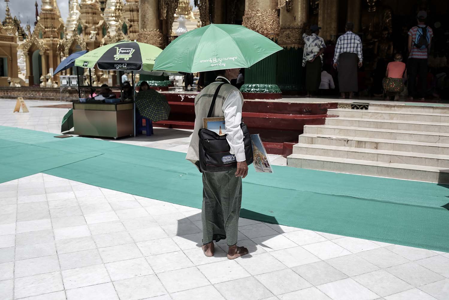 Fotografer menunggu pelanggan di Pagoda Shwedagon Myanmar. Sepinya kunjungan wisatawan memangkas pendapatan.