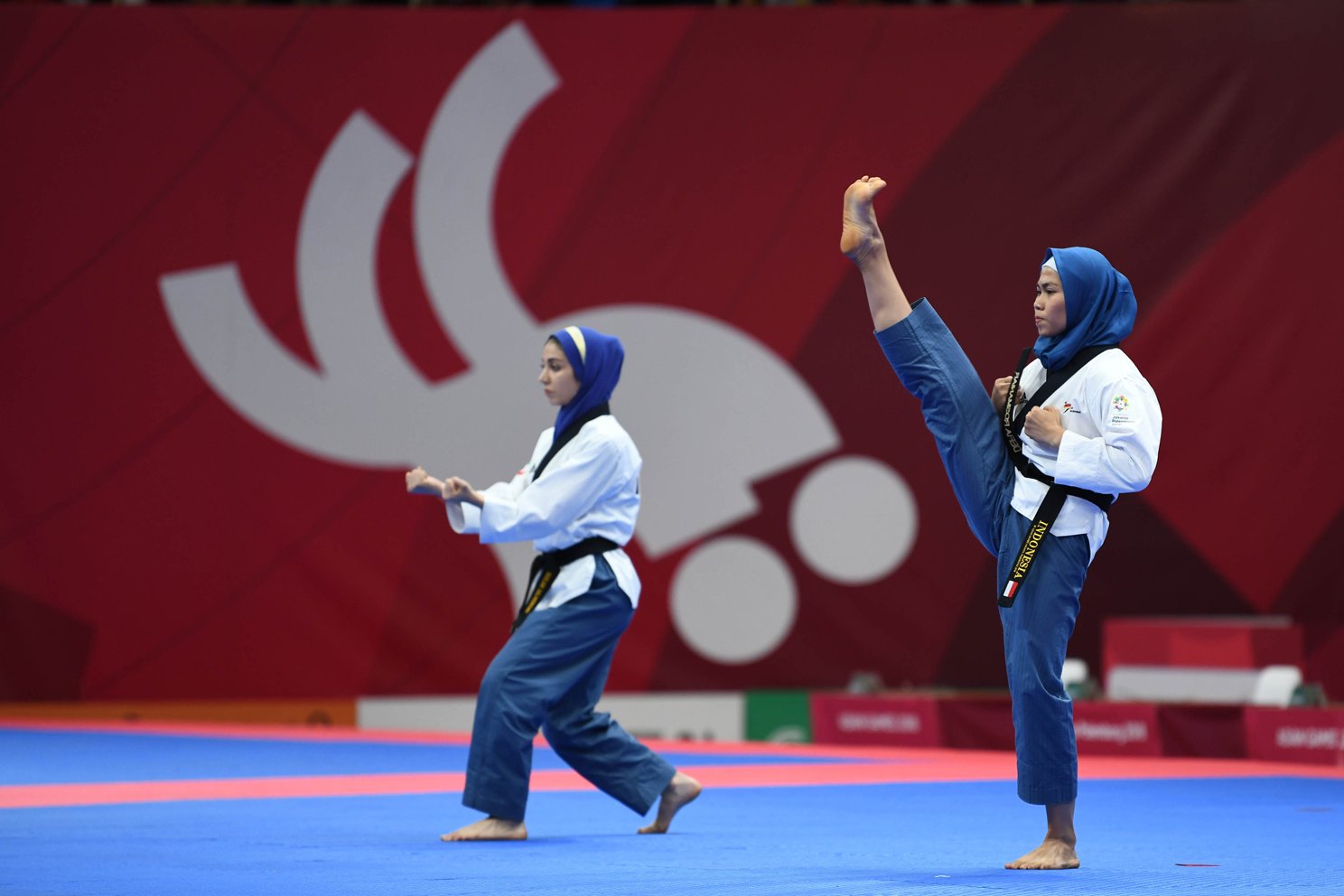 Taekwondoin putri Indonesia Rosmaniar Defia (kanan) berhadapan dengan atlet Taekwondo putri Iran Marjan Salahshouri dalam partai final poomsae tunggal putri pada Asian Games 2018 di Jakarta Convention Center (JCC), Defia menang dan memperoleh medali emas untuk Indonesia. Minggu (19/8). 