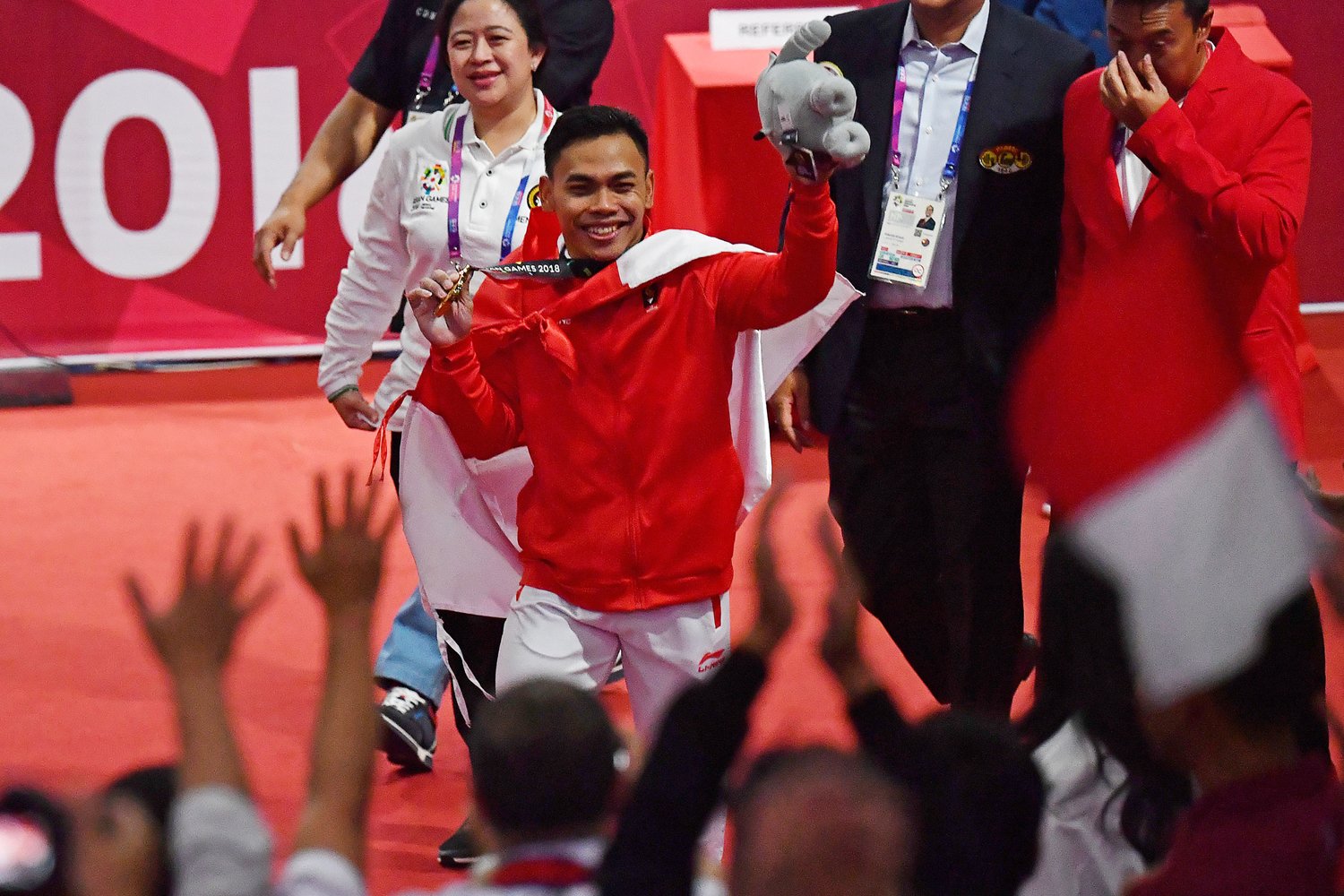 Menko PMK Puan Maharani (kiri) dan Menpora Imam Nahrawi (kanan) mendampingi lifter Indonesia Eko Yuli Irawan menyapa penonton usai nomor angkat besi putra 62 kg Group A Asian Games ke-18 2018 di JiExpo Jakarta, Senin (20/8). Eko berhasil meraih emas pada nomor tersebut. 