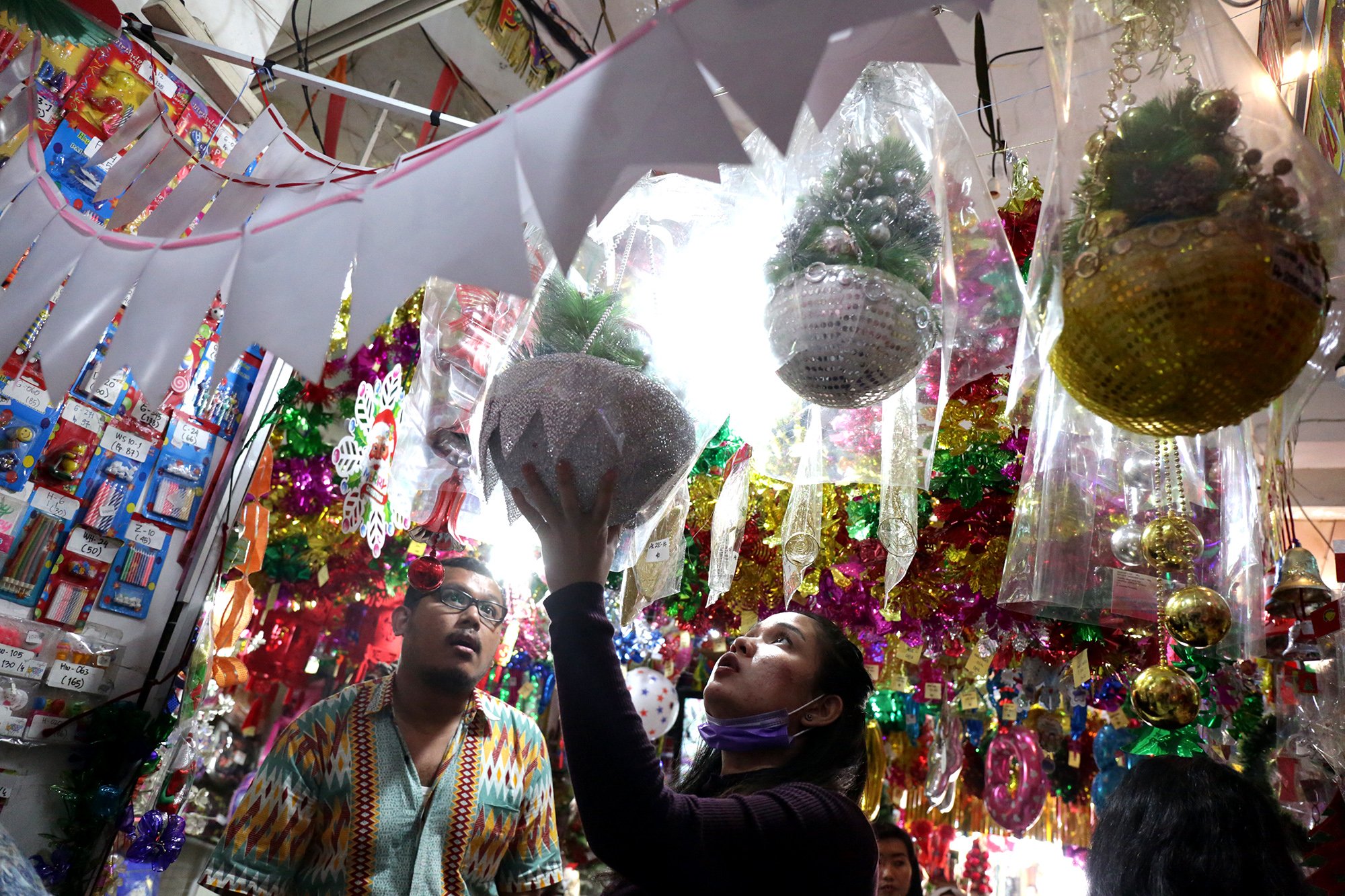 Dua orang pengunjung sedang melihat pernak pernik Natal di pasar Asemka, Jakrta Pusat (10/12). Para pembeli biasanya mulai memadati toko pada bulan November.