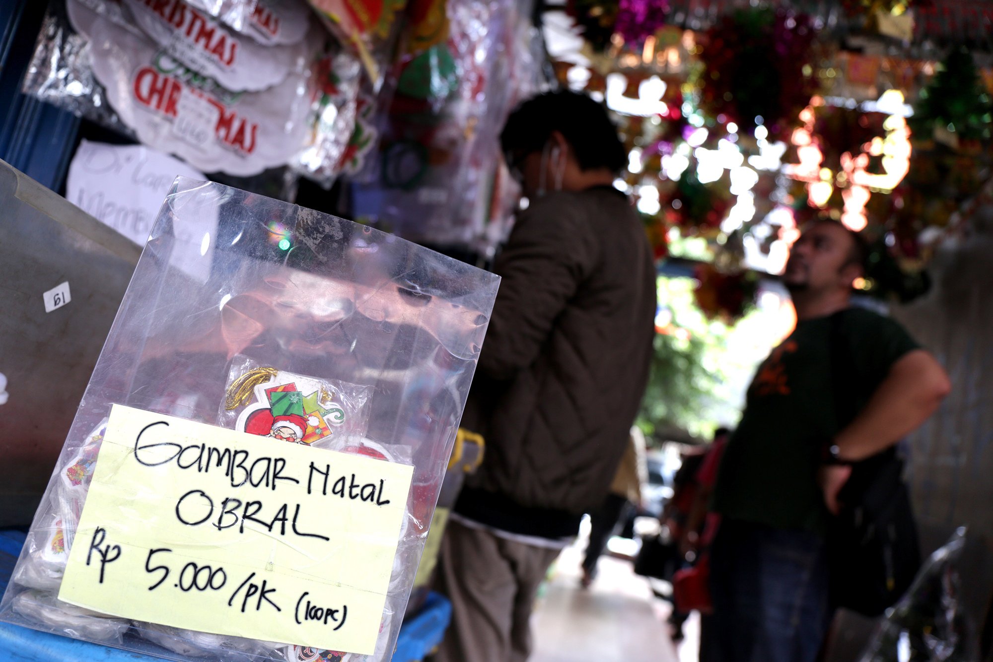 Dua orang pengunjung sedang melihat pernak pernik Natal di pasar Asemka, Jakrta Pusat (10/12). Banyak barang natal yang di obral di Pasar Asemka.