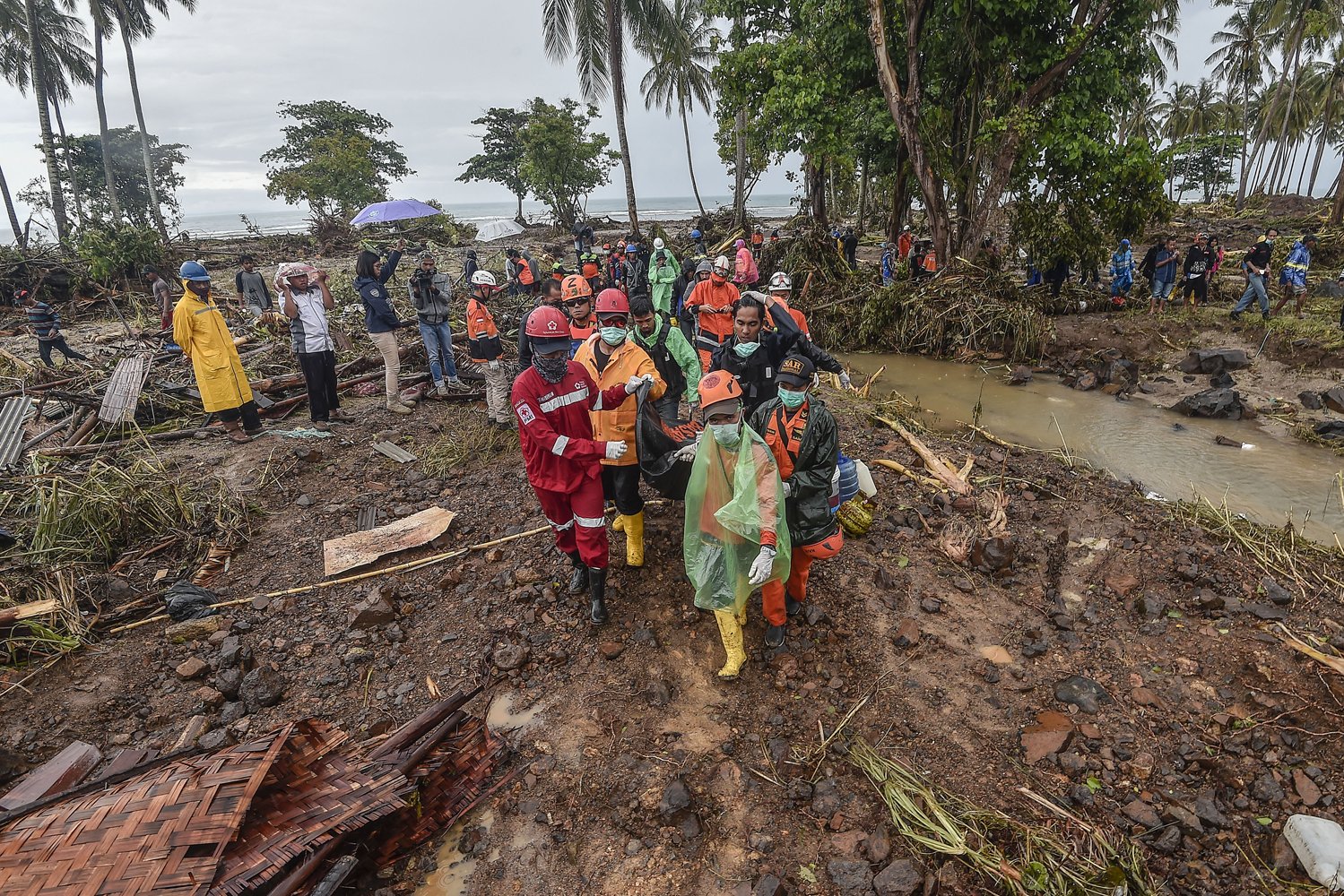 Petugas Basarnas bersama relawan menghadapi akses yang sulit dalam mengevakuasi jenazah korban gelombang tsunami Selat Sunda di Kecamatan Sumur, Pandeglang, Banten, Selasa (25/12/2018). 