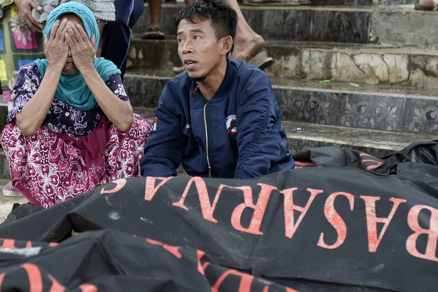 Keluarga menunggu jenazah korban tsunami di Desa Way Muli, Kalianda, Lampung Selatan, Lampung, Senin (24/12/2018).