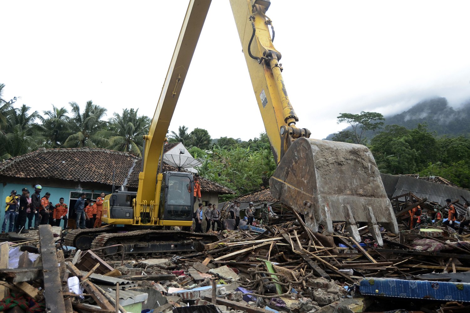 Alat berat digunakan untuk membersihkan reruntuhan bangunan yang tersapu tsunami di Desa Way Muli, Kalianda, Lampung Selatan, Lampung, Senin (24/12/2018). 