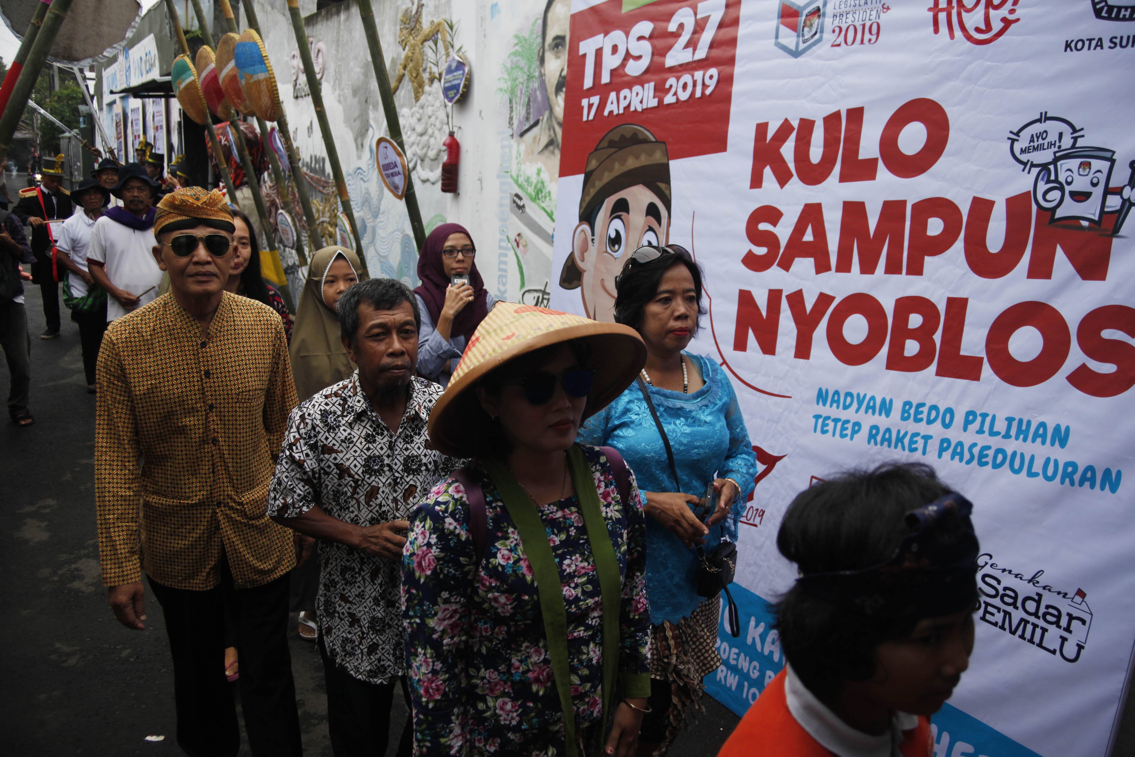 Warga mengikuti kirab menuju Tempat Pemungutan Suara (TPS) 27 Kampung Happy, Manahan, Solo, Jawa Tengah, Rabu (17/4/2019). Aksi tersebut merupakan bentuk antusiasme warga setempat menyambut pesta demokrasi Pemilu 2019.