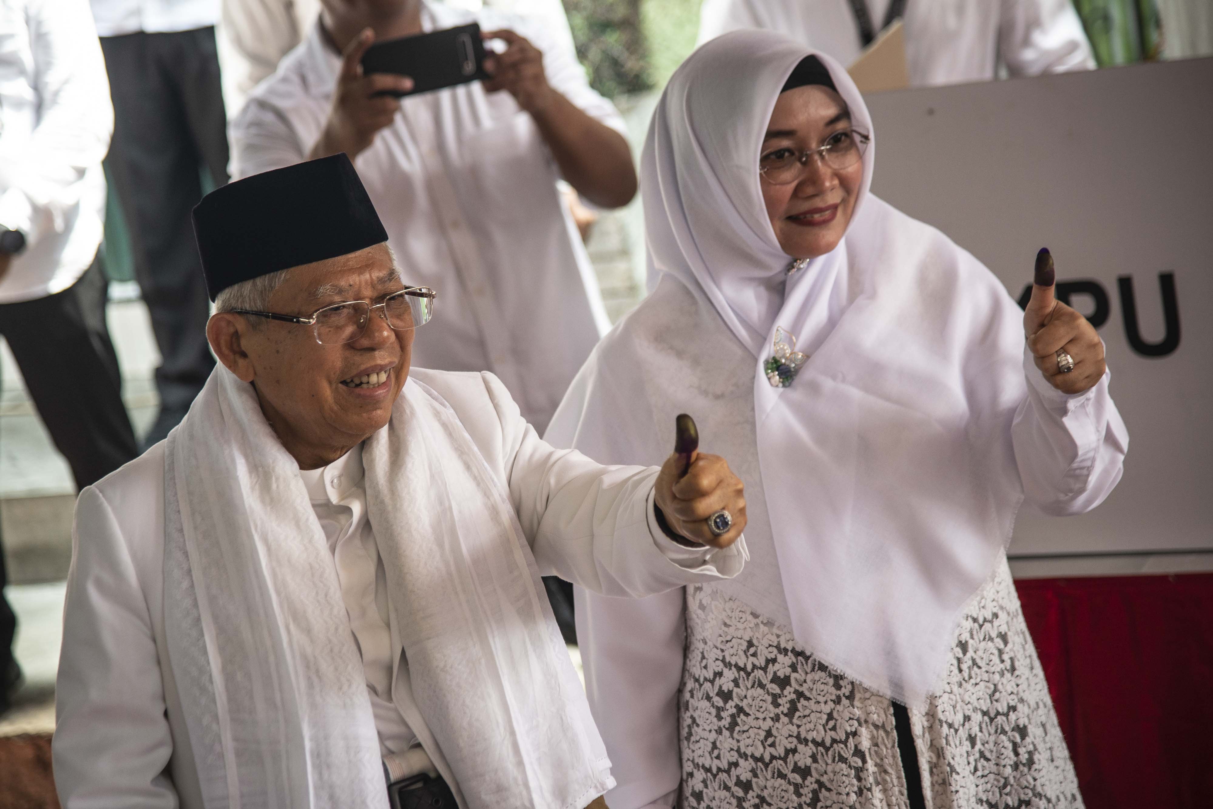 Calon Wakil Presiden Nomor Urut 01 Ma\'ruf Amin (kiri) bersama istrinya Wury Estu Handayani (kanan) menunjukkan jempolnya seusai menggunakan hak pilihnya dalam Pemilu 2019, di TPS 051, Koja, Jakarta, Rabu (17/4/2019). 