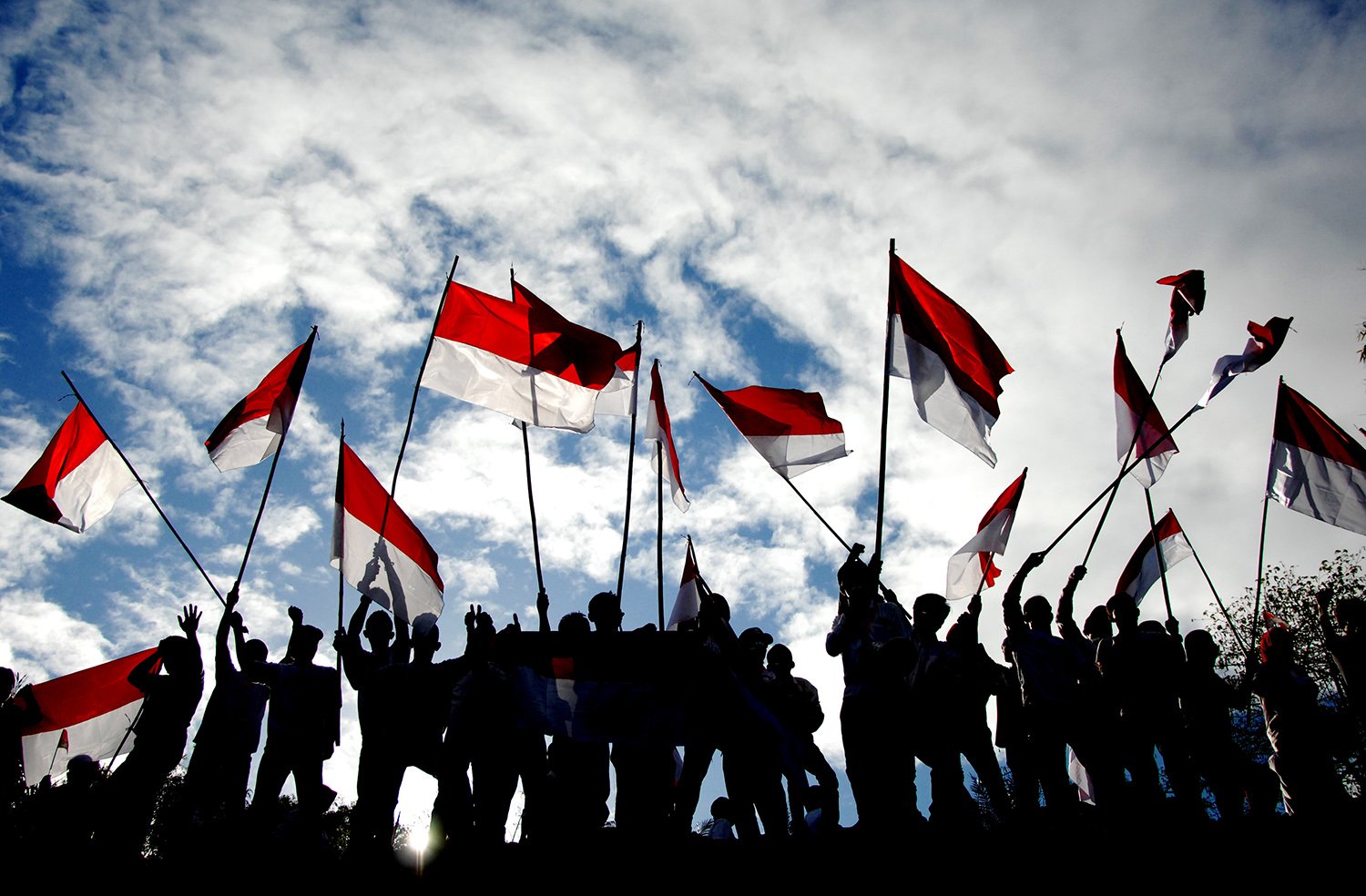 Sejumlah warga membawa bendera merah putih saat mengikuti upacara bendera memperingati HUT ke-74 Kemerdekaan RI di Bukit Tokka, Desa Bontomarannu, Kabupaten Maros, Sulawesi Selatan, Sabtu (17/8/2019). Upacara bendera peringatan hari kemerdekaan RI yang digelar di atas bukit tersebut diikuti ratusan warga dari sejumlah kalangan. 