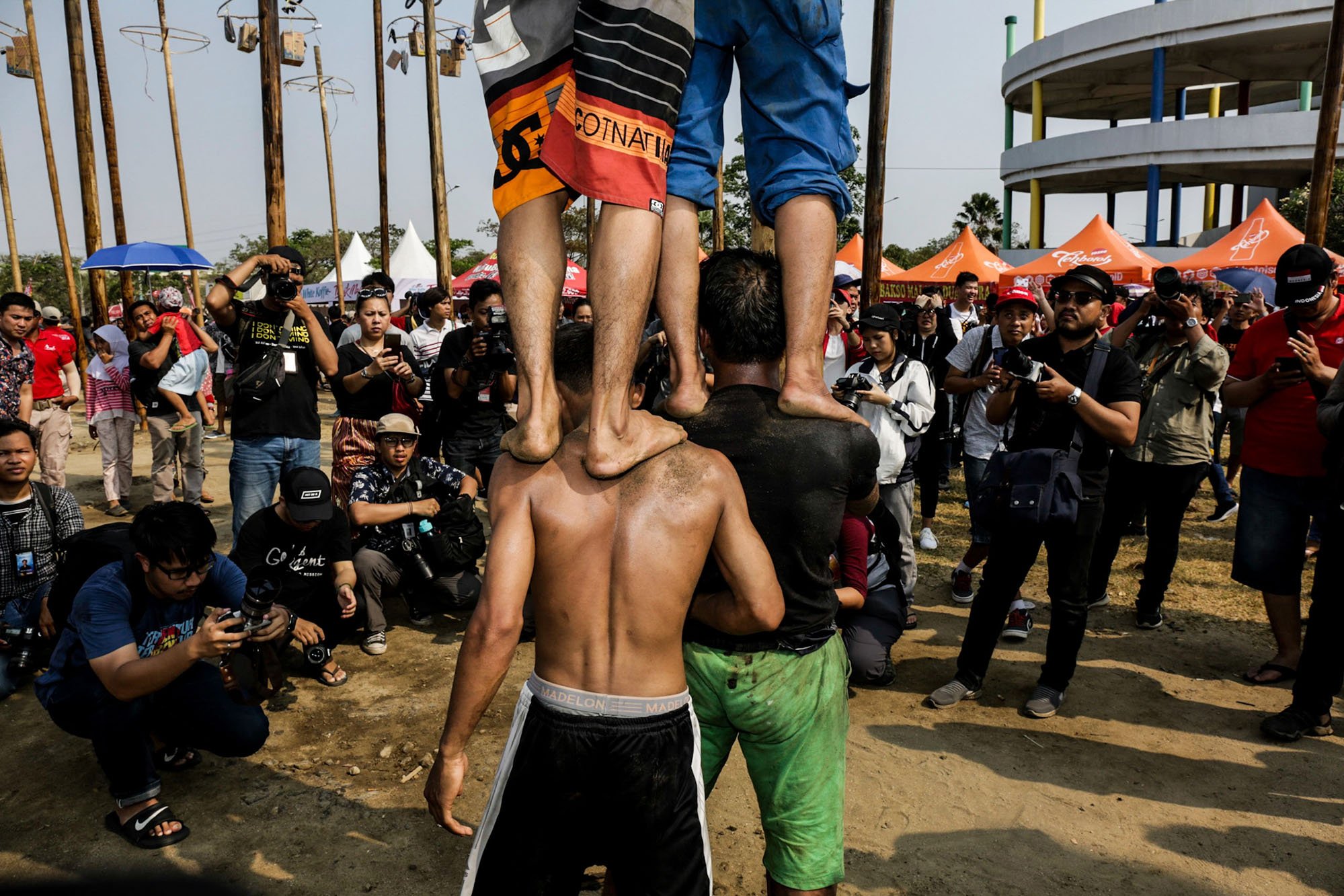 Sejumlah para penghobi fotografi memotret lomba panjat pinang di Pantai Carnaval, Ancol, Jakarta Utara, Rabu (17/8/2019). Ancol juga telah menyiapkan sebanyak 174 batang pinang untuk dipanjat oleh warga dengan total hadiah pada masing-masing pohon senilai Rp 1,5 juta.