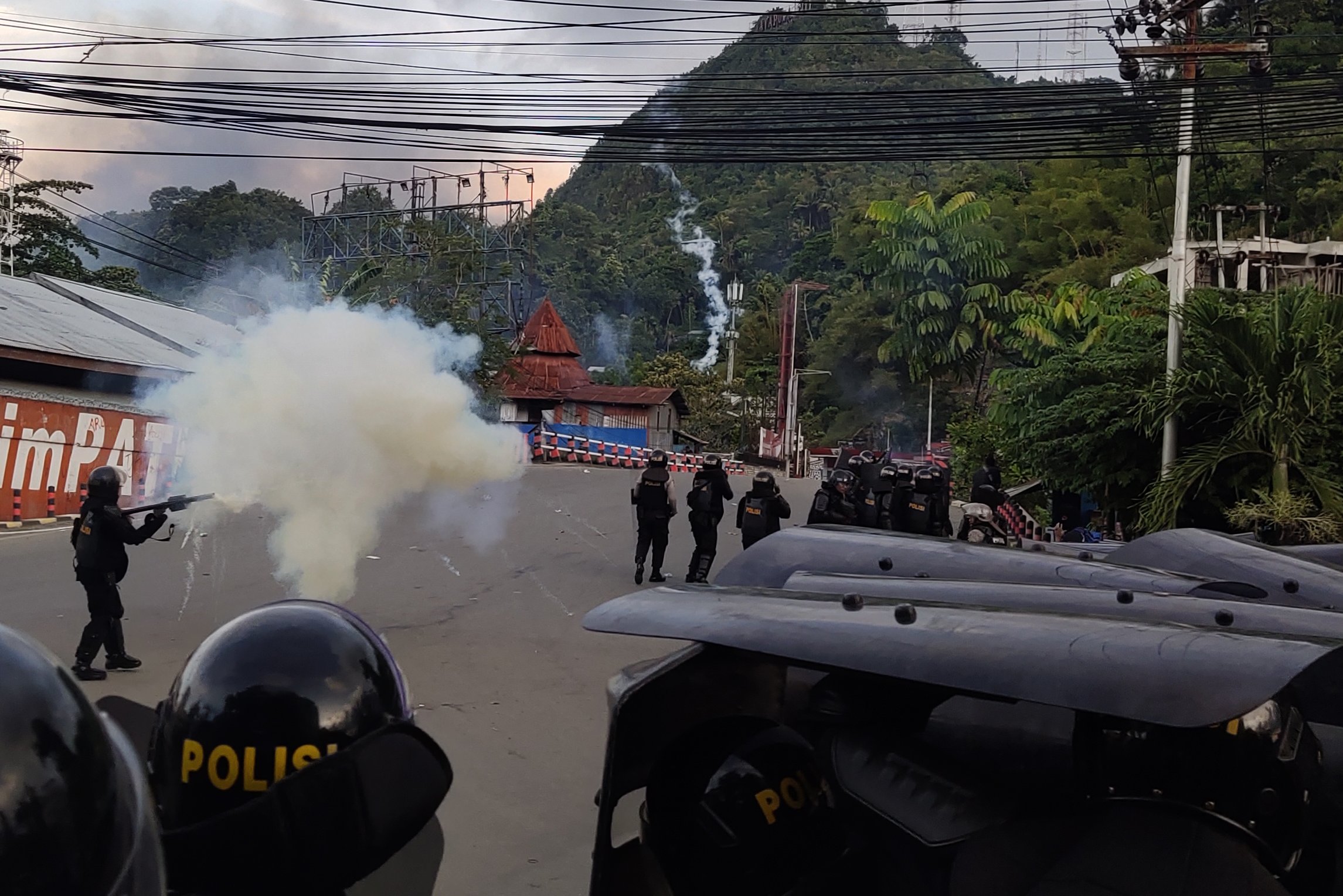 Petugas kepolisian melepaskan tembakan gas air mata untuk menghalau massa saat berlangsungnya aksi unjuk rasa di Jayapura, Papua, Kamis (29/8/2019). 