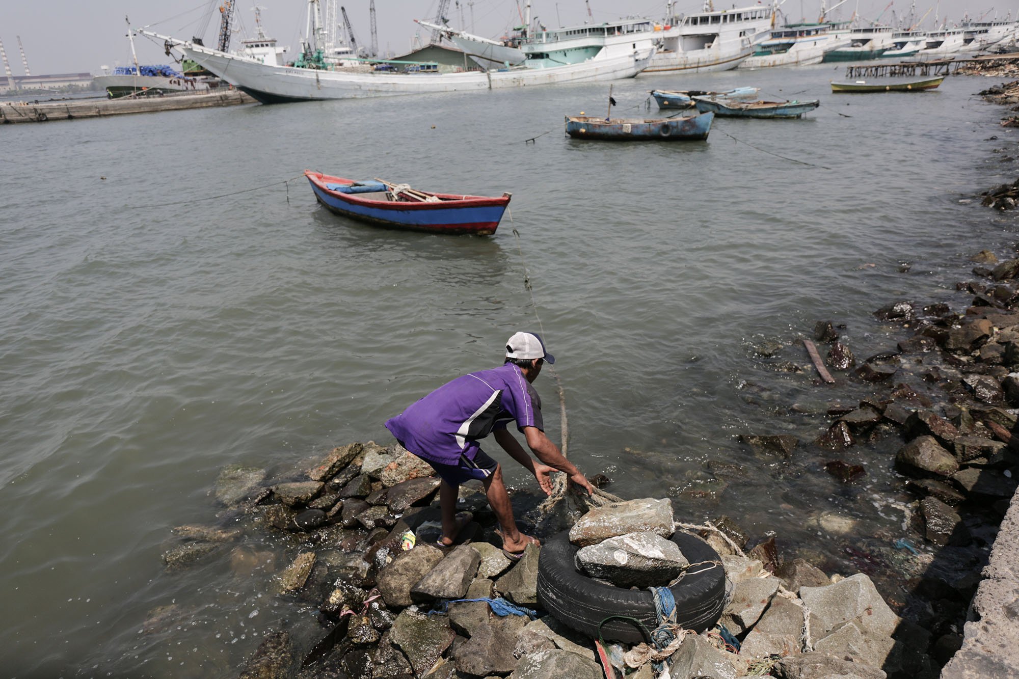 Wahyu (48) menarik kapalnya di Pantai Muara Baru, Jakarta Utara (11/9).