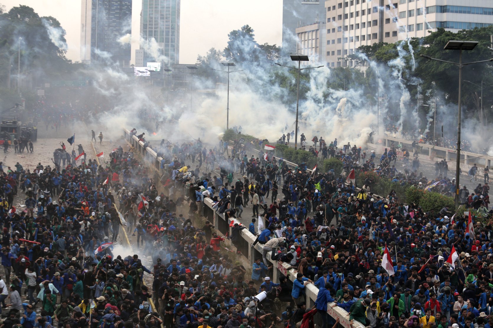 Polisi melontarkan gas air mata saat kericuhan dalam unjuk rasa di depan kompleks Parlemen di Jakarta, Selasa (24/9/2019). Ribuan mahasiswa yang berasal dari kampus di sejumlah daerah itu turun ke jalan berdemonstrasi menolak UU KPK dan pengesahan RUU KUHP.\r\n