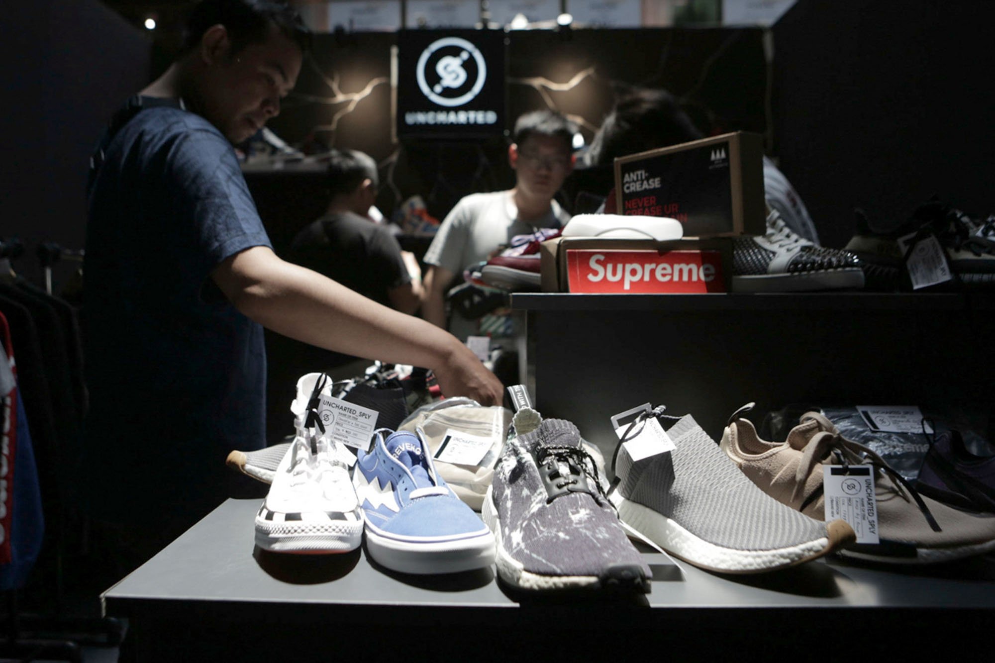 Seorang pengunjung memegang sepatu di salah satu both dalam bazar Urban Sneaker Society di ke Plaza Gedung District 8, SCBD, Jakarta Selatan (08/11/2019). Terdapat beberapa brand sepatu yang merilis produk hasil kolaborasi eksklusifnya, diantaranya sepatu Compass, Untold, Rafheoo Footwear, hingga G-Shock. Selain itu, ada pula kolaborasi eksklusif seperti ublic Culture, FR2 (Fxxcking Rabbit), Atmos, hingga Round Two by Sean Wotherspoon.