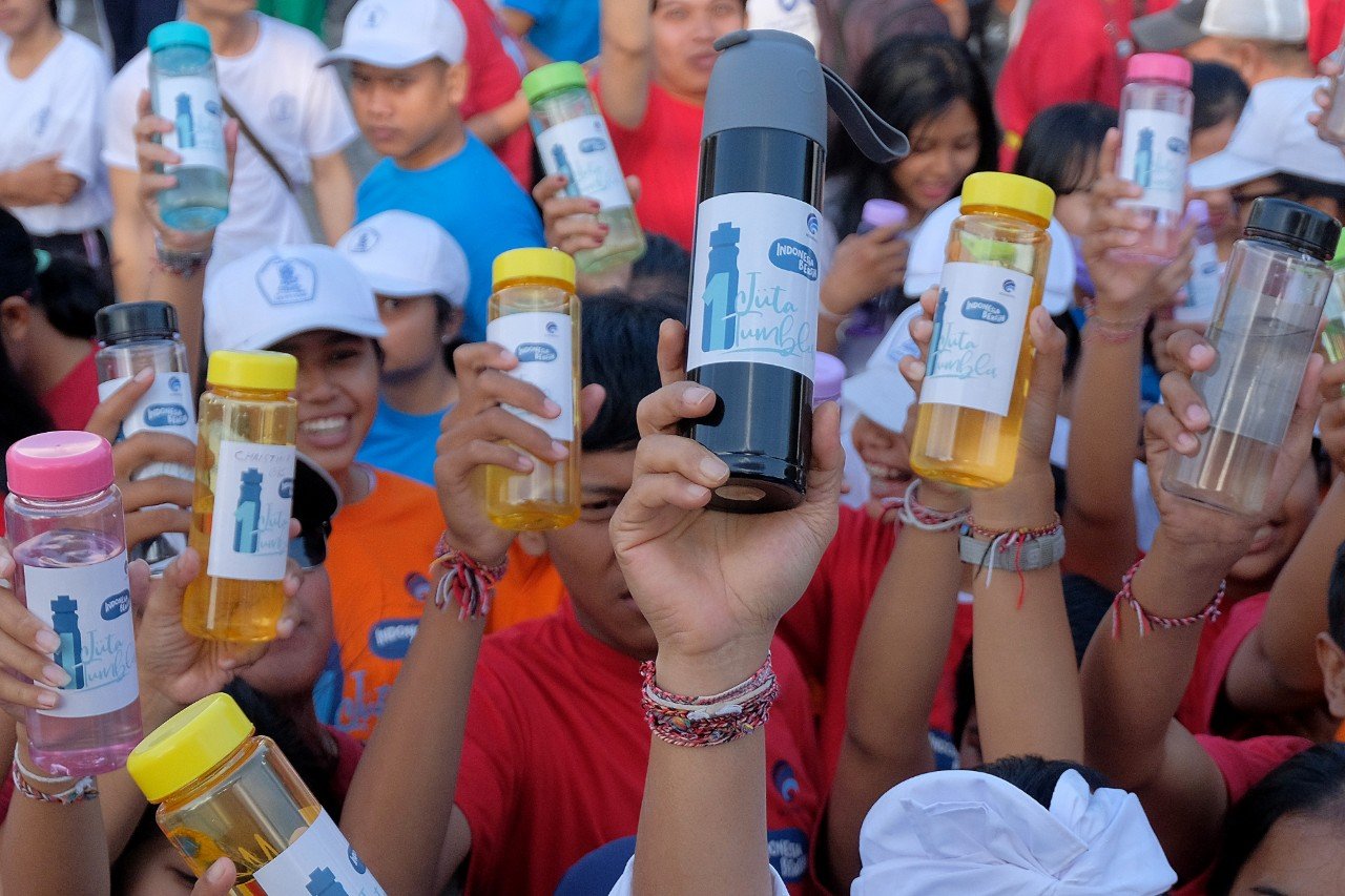 Warga menunjukkan tumbler atau botol minuman dalam acara Indonesia Bersih Melalui Gerakan Satu Juta Tumbler di kawasan Pantai Matahari Terbit Sanur.\r\n