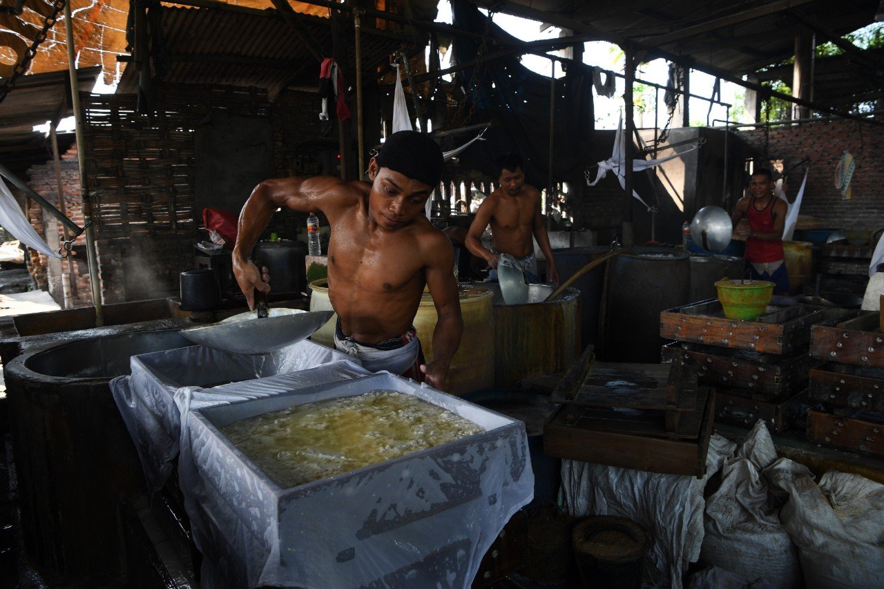 Pekerja menyelesaikan pembuatan tahu di salah satu pabrik tahu yang menggunakan bahan bakar sampah plastik di Tropodo, Sidoarjo, Jawa Timur, Rabu (20/11/2019)