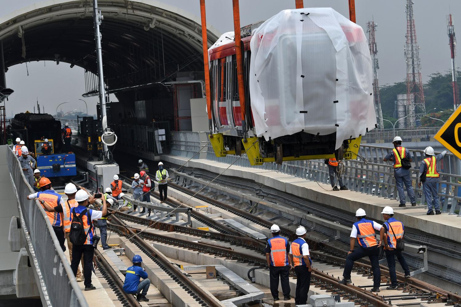 Sejumlah petugas mengawasi proses pengangkatan gerbong kereta 'light rail train' atau lintas rel terpadu (LRT) ke atas rel di Stasiun Harjamukti, Cimanggis, Kota Depok, Jawa Barat, Rabu (4/12/2019). 