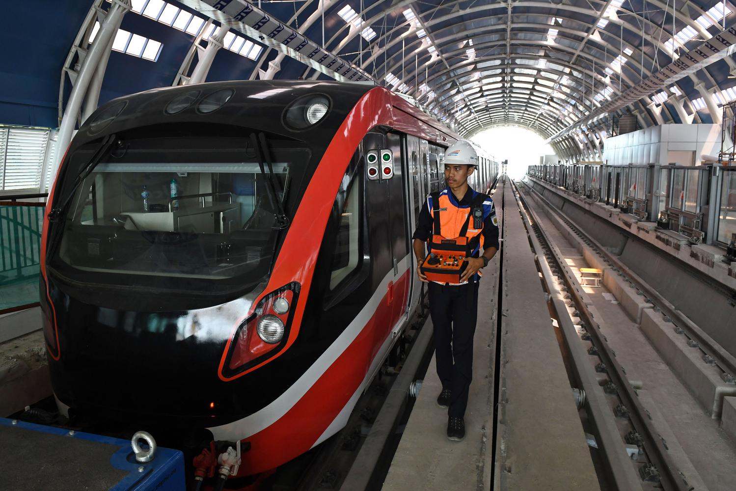 Petugas melintasi gerbong kereta 'light rail train' atau lintas rel terpadu (LRT) di Stasiun Harjamukti, Cimanggis, Kota Depok, Jawa Barat, Rabu (4/12/2019). LRT Jabodebek koridor Cibubur-Dukuh Atas mempunyai kapasitas sebanyak 250 orang per gerbong 