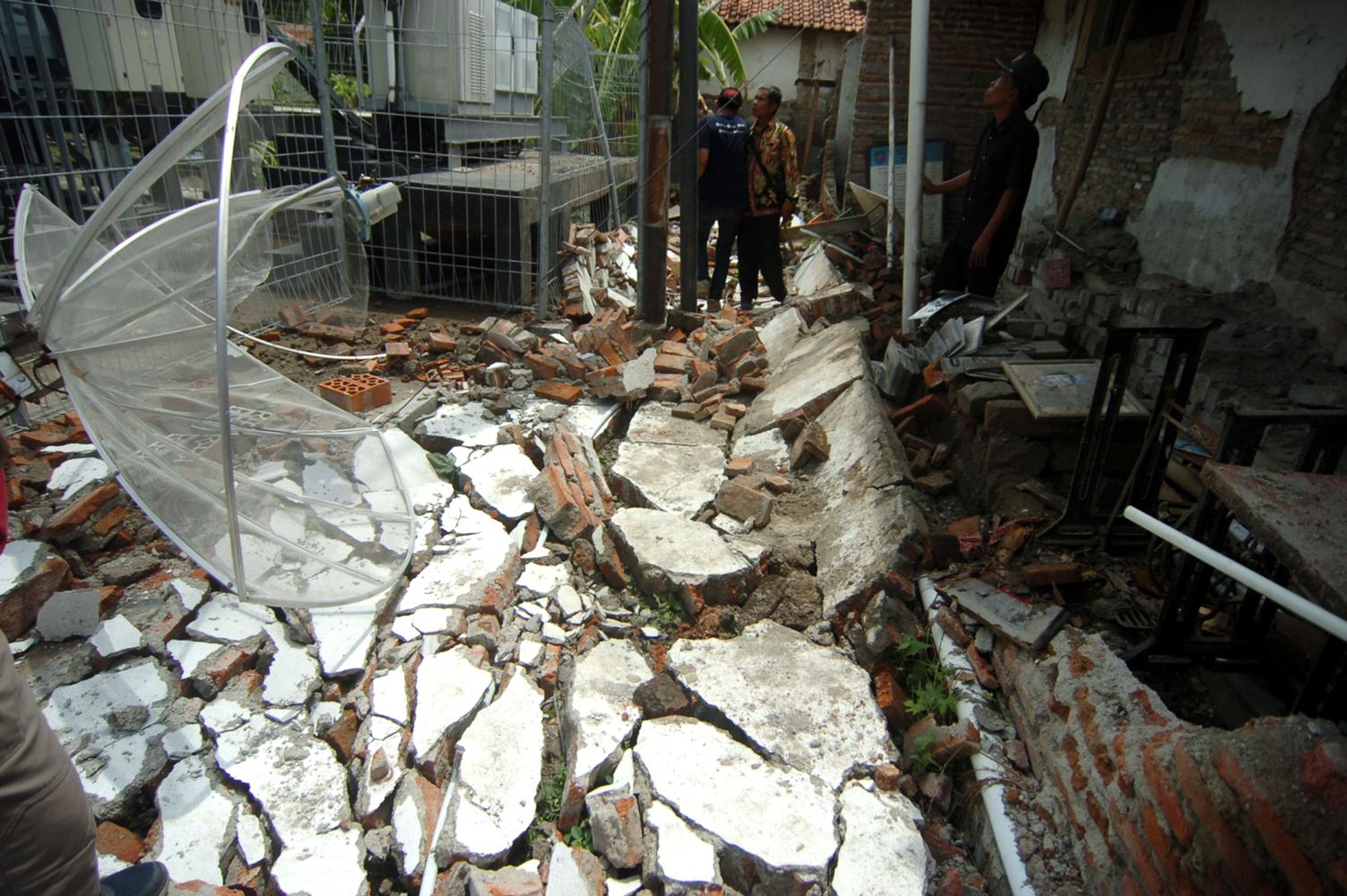 Petugas membersihkan puing-puing tembok yang ambruk di Balaidesa Kertayasa, Kabupaten Tegal, Jawa Tengah, Kamis (5/12/2019). Tembok balai desa setinggi tiga meter dan panjang 15 meter tersebut ambruk akibat hujan deras disertai angin kencang.