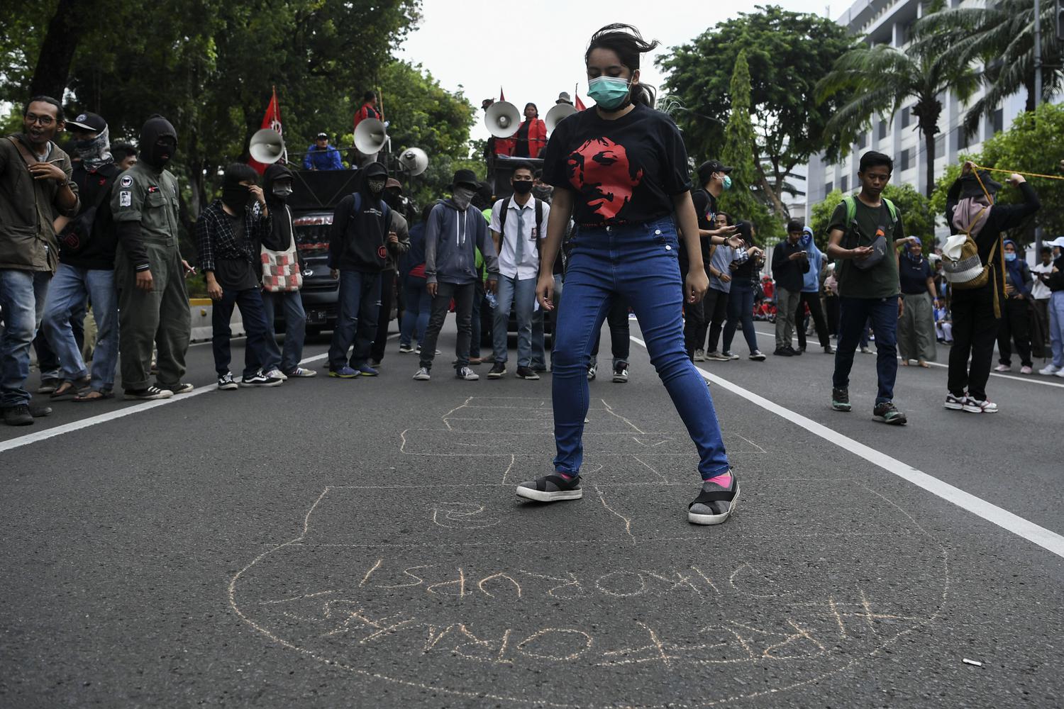 Peserta aksi mencoba permainan tradisional saat mengikuti berunjuk rasa di depan Istana Merdeka Jakarta, Selasa (10/12/2019). Aksi yang diikuti massa dari berbagai elemen masyarakat tersebut dalam rangka memperingati Hari Hak Asasi Manusia Sedunia.