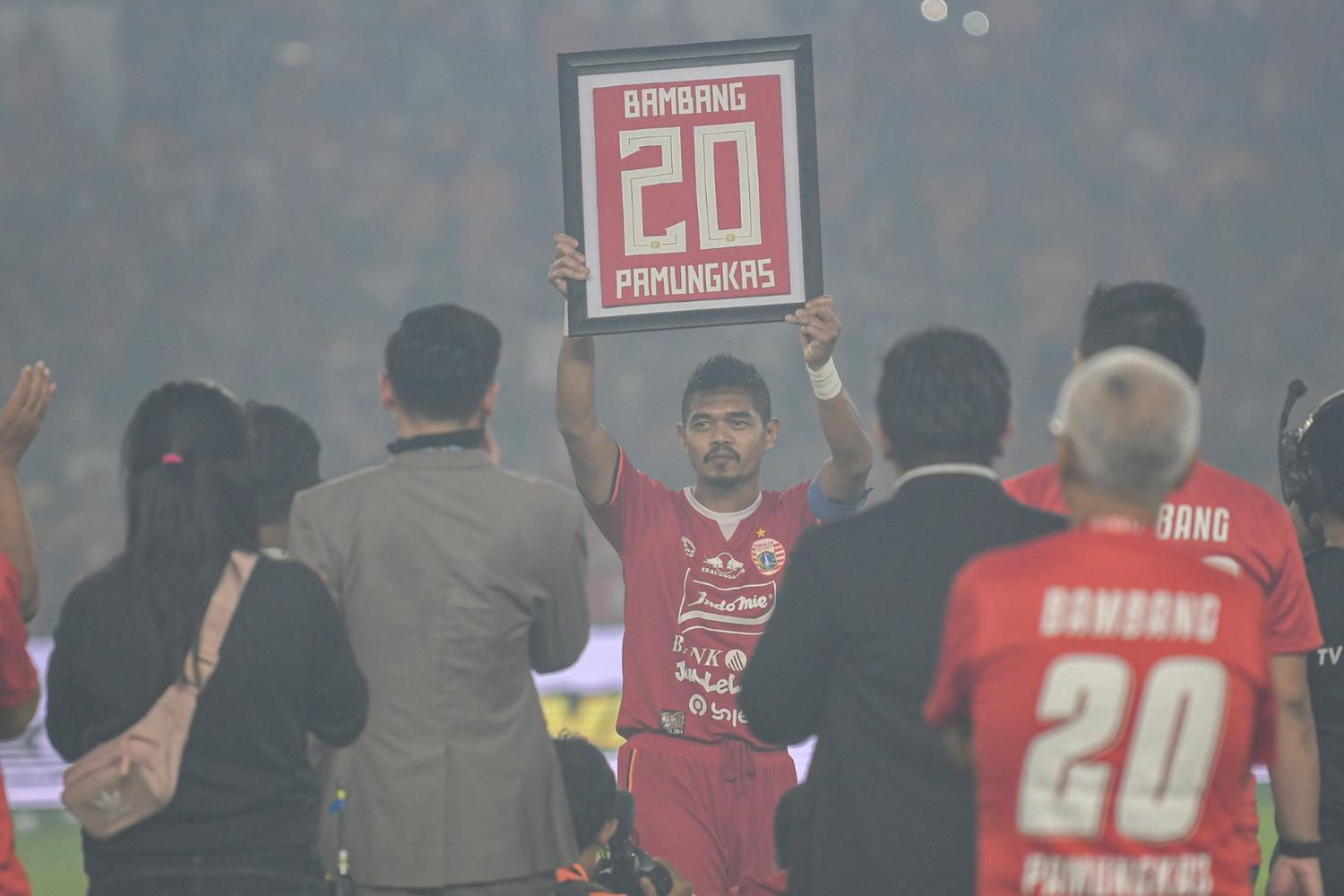 Pesepak bola Persija Jakarta Bambang Pamungkas (tengah) mengangkat kostum miliknya yang dibingkai usai melawan Persebaya Surabaya dalam lanjutan Liga 1 di Stadion Utama Gelora Bung Karno (GBK), Jakarta, Selasa (17/12/2019). 