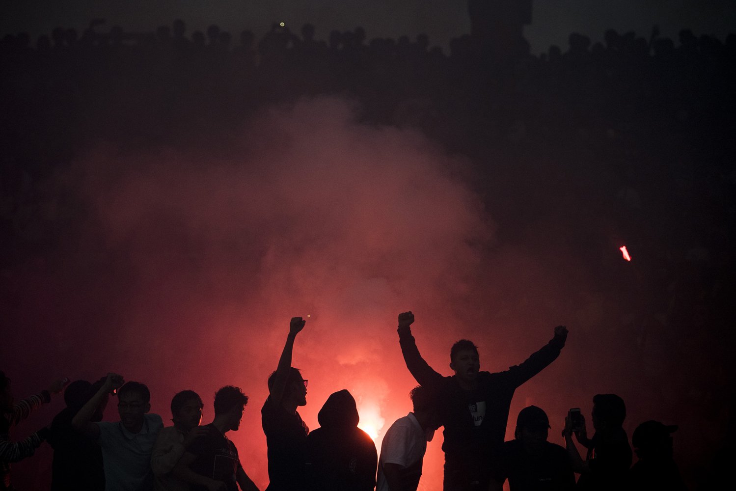 Siluet suporter Persib Bandung menyalakan suar seusai pertandingan melawan PSM Makassar pada Liga 1 2019 di Stadion Si Jalak Harupat, Kabupaten Bandung, Jawa Barat, Minggu (22/12/2019). Pertandingan tersebut dimenangkan Persib Bandung dengan skor 5-2. 