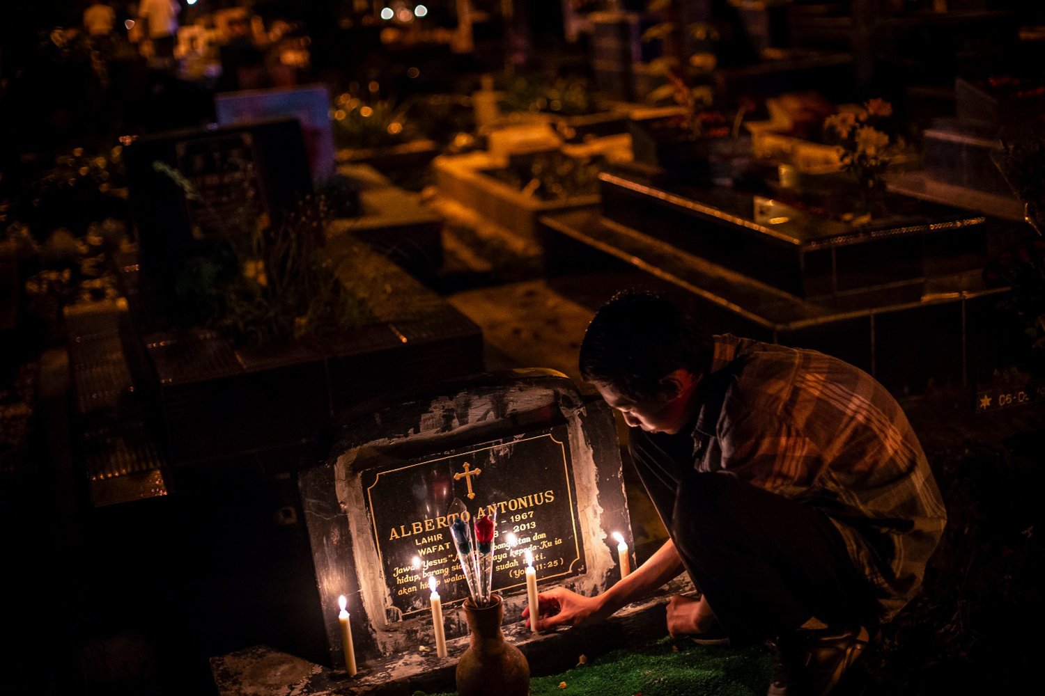 Warga keturunan Portugis menyalakan lilin saat melakukan ziarah ke makam anggota keluarga mereka pada malam Natal di kompleks Gereja Protestan Indonesia Barat (GPIB) Tugu, Semper Barat, Cilincing, Jakarta Utara, Selasa (24/12/2019). Ziarah tersebut menjadi tradisi keluarga keturunan Portugis di Kampung Tugu menjelang Hari Raya Natal. 