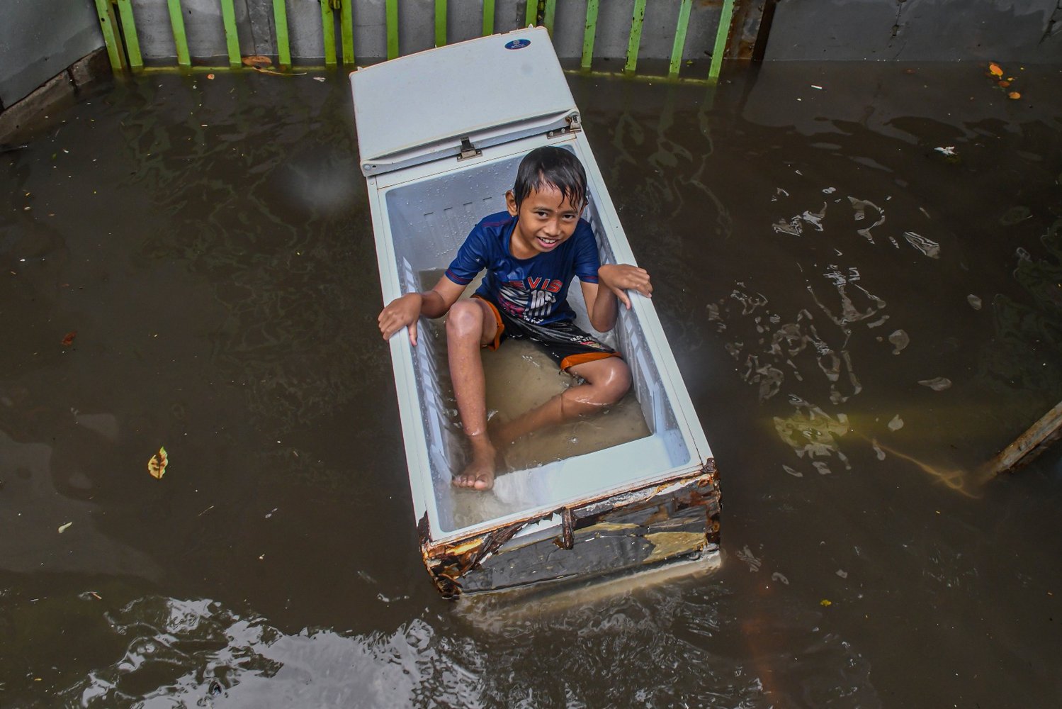 Seorang bocah bermain saat banjir melanda kawasan Sunter, Jakarta, Rabu (25/12/2019). Banjir di kawasan tersebut diakibatkan hujan deras dan tersumbatnya saluran air oleh sampah.