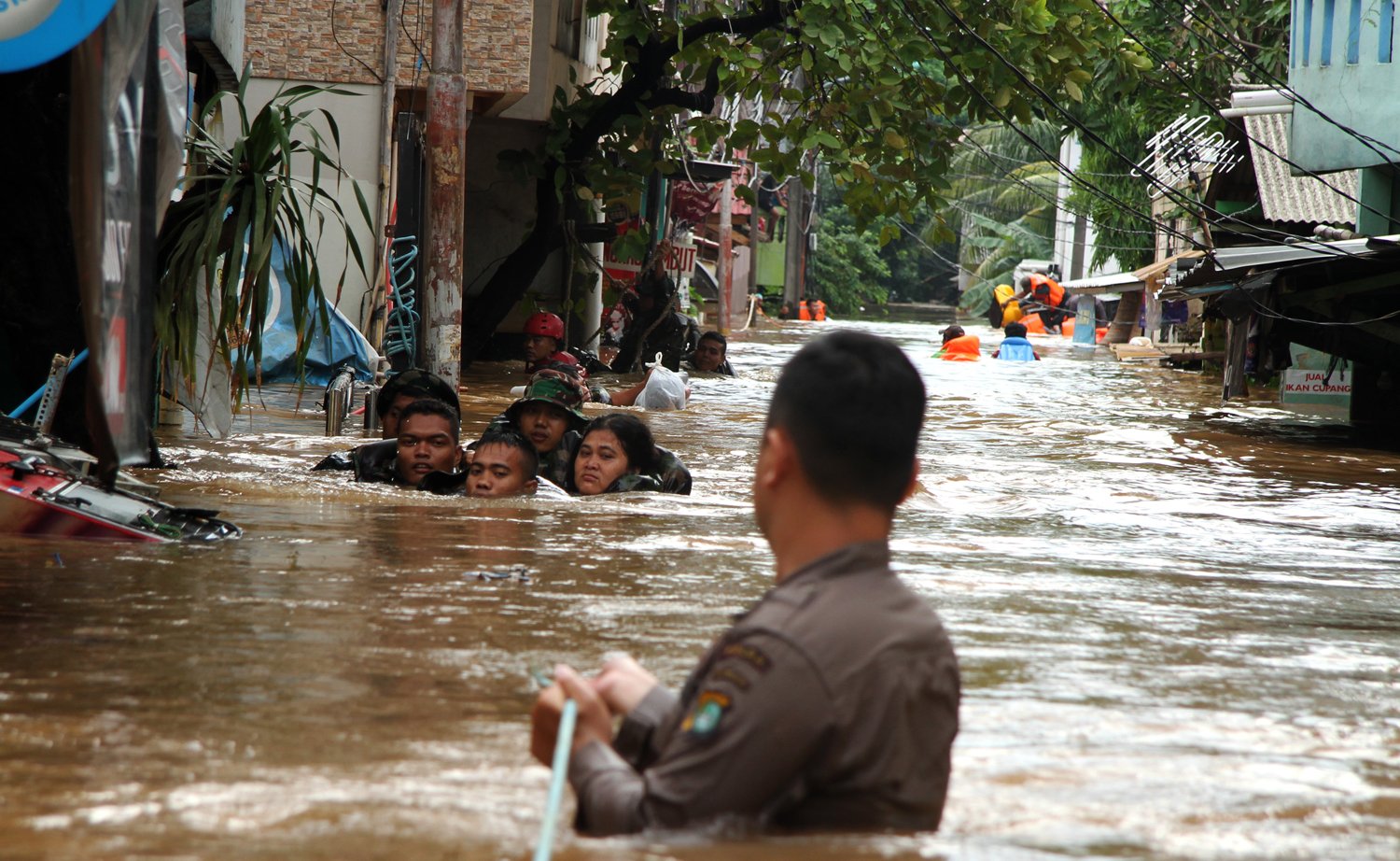 Personel Brimob Polri dan TNI mengevakuasi warga yang terjebak banjir di kawasan permukiman Cipinang Melayu, Jakarta, Rabu (1/1/2020). Banjir tersebut akibat luapan sungai Sunter yang diperparah tingginya intensitas curah hujan sejak Selasa (31/12/2019) malam. 