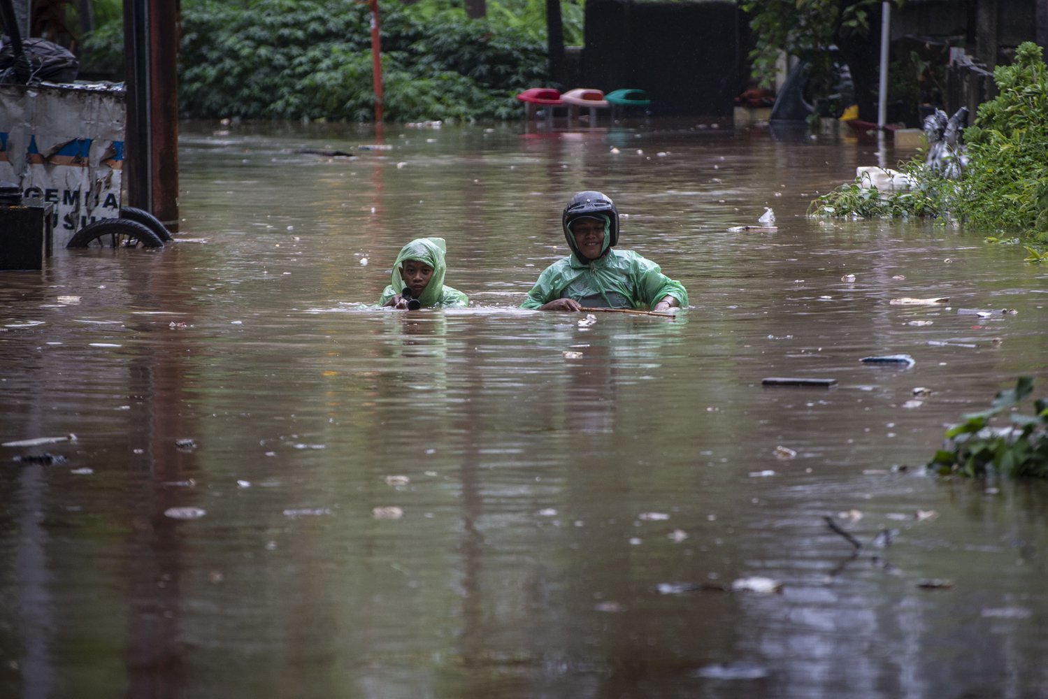 Warga berjalan melintasi genangan banjir di kawasan Karet Semanggi, Jakarta, Rabu (1/1/2020). Banjir tersebut disebabkan karena tingginya intensitas hujan yang mengguyur sejak Selasa (31/12/2019). 