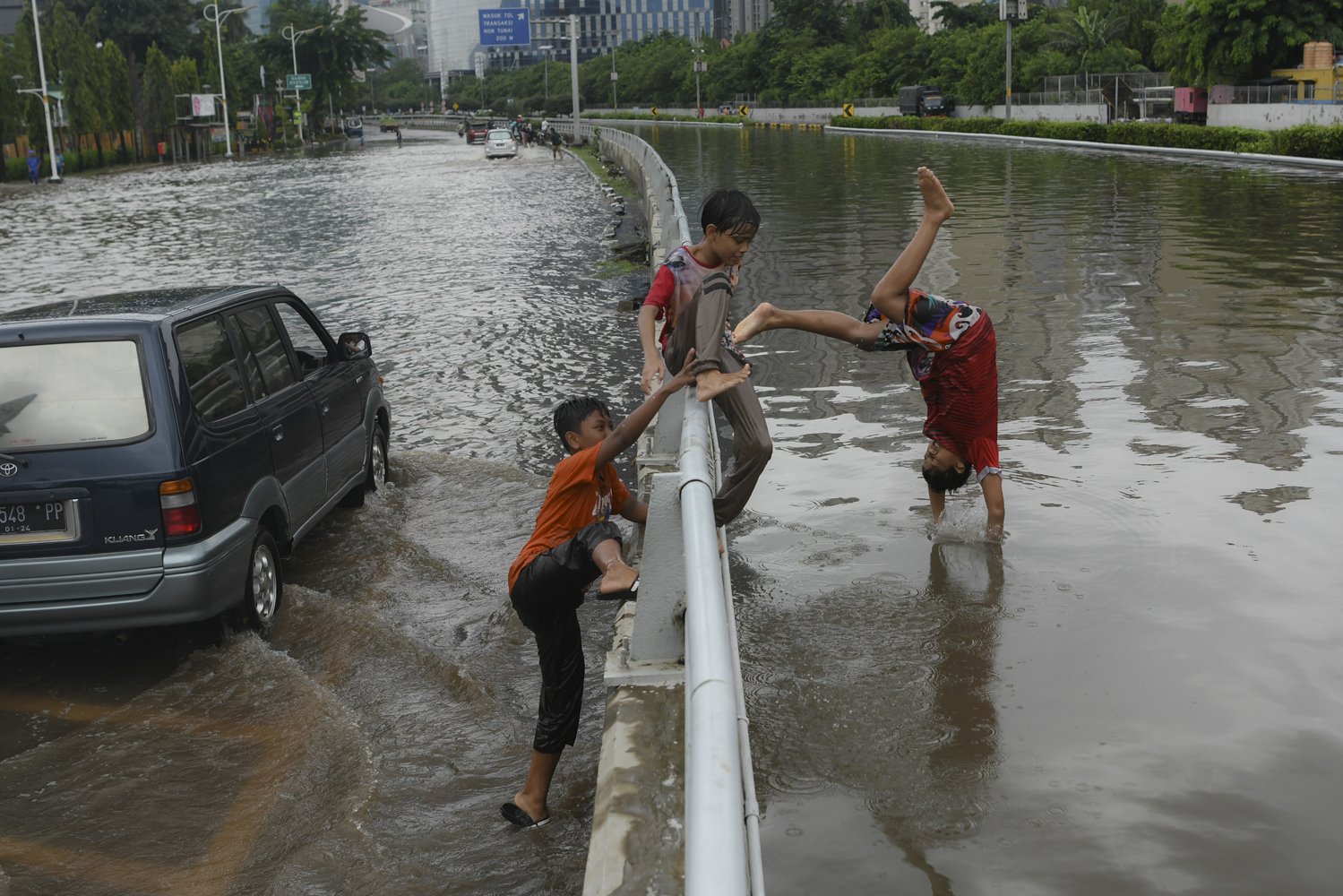 Sejumlah bocah bermain saat banjir yang merendam Jalan Letjen S Parman dan tol dalam kota di Jakarta Barat, Rabu (1/1/2020). Hujan lebat yang mengguyur Jakarta sejak Selasa (31/1/2019) malam menyebabkan sejumlah wilayah itu terendam banjir. \r\n